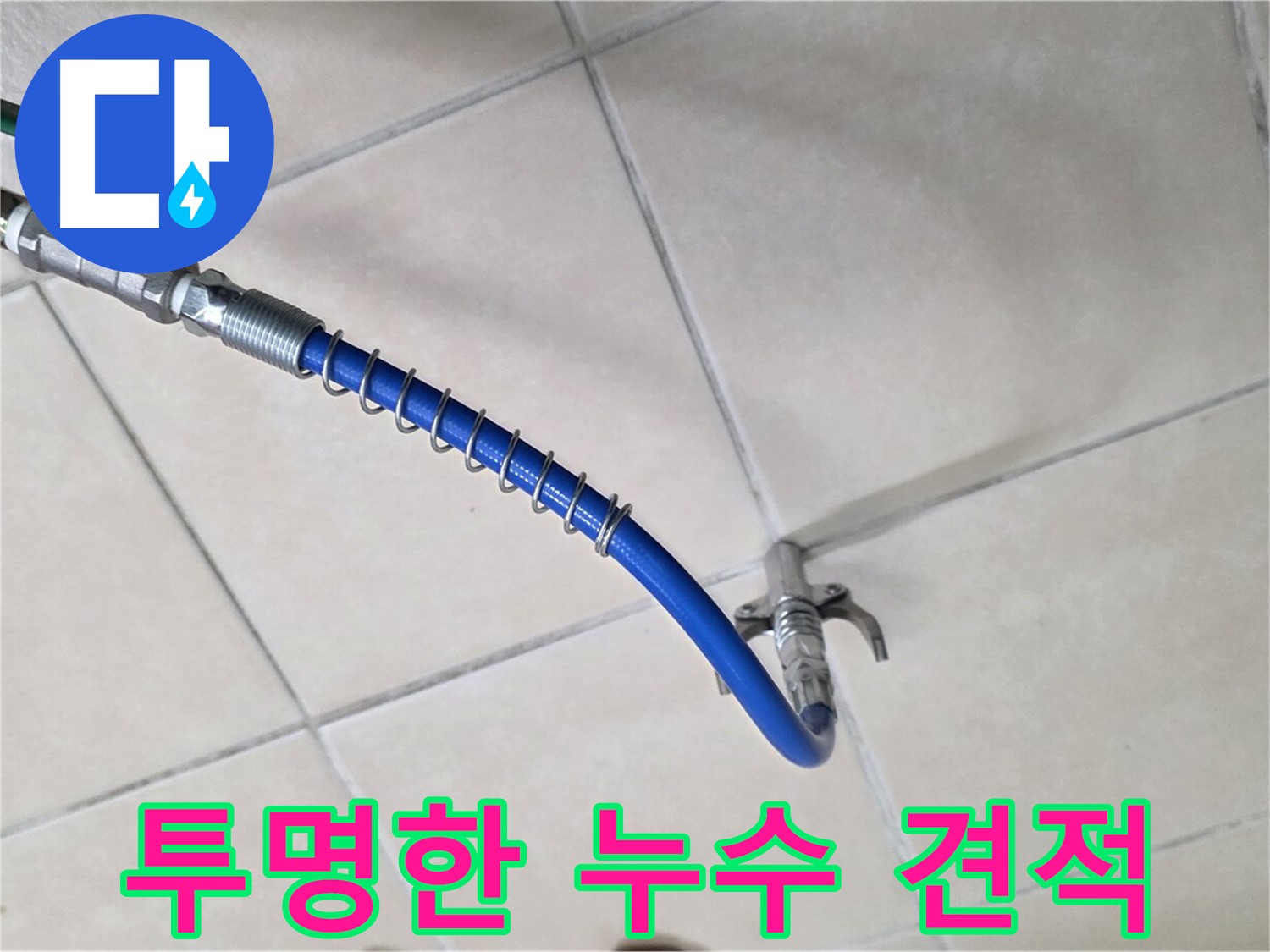 타일 바닥에 설치된 파란색 호스와 배관 연결 부속