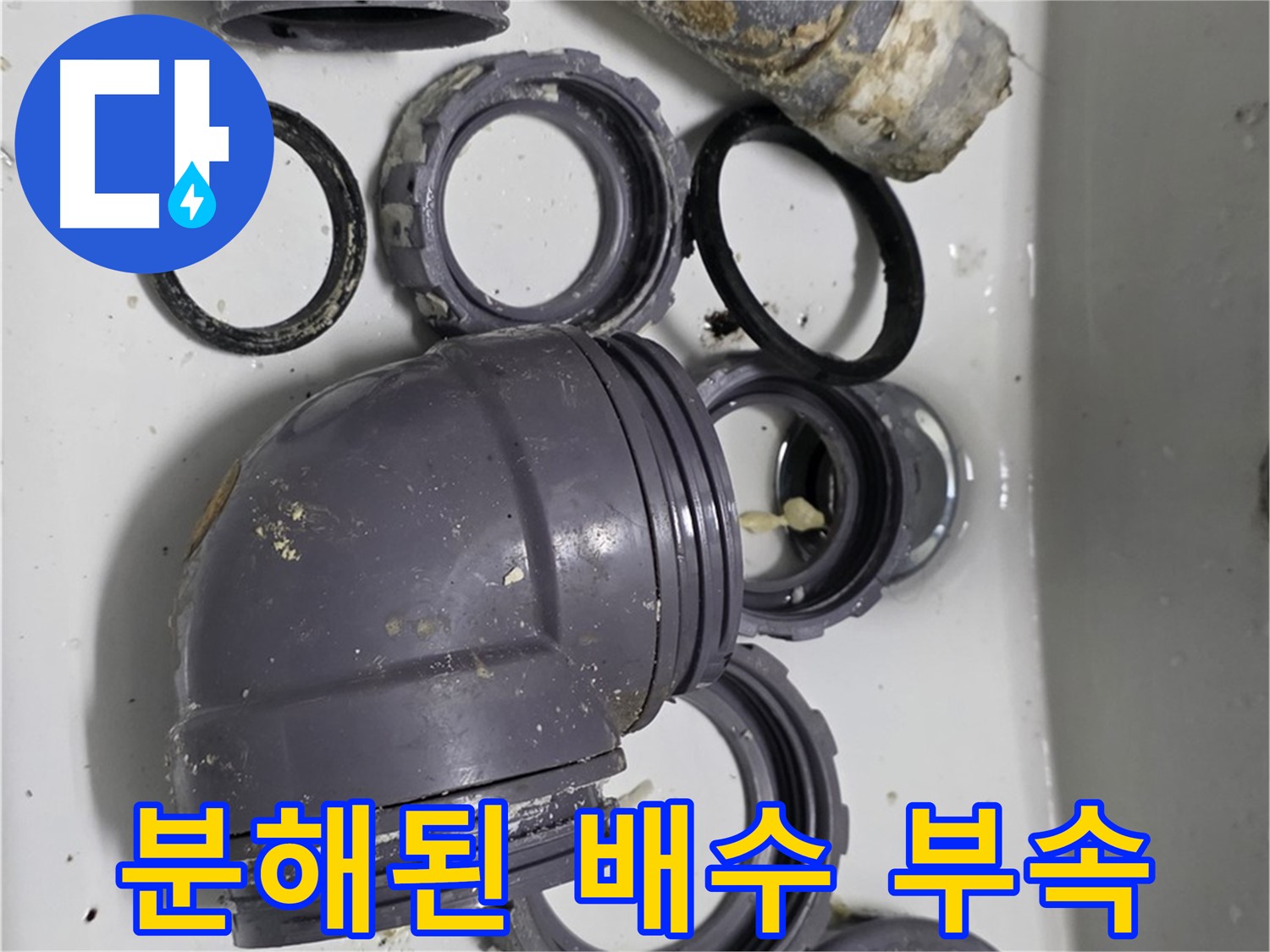 분해된 배수 부속 - 누수 원인 파악을 위해 분해된 싱크대 배수 부속 전체 모습입니다.