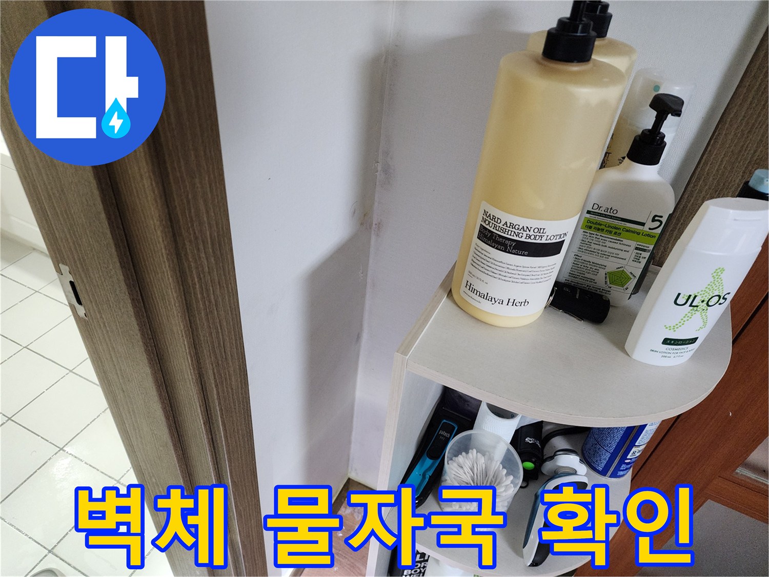선반 뒤쪽 벽면에 나타난 누수 흔적과 얼룩진 부위