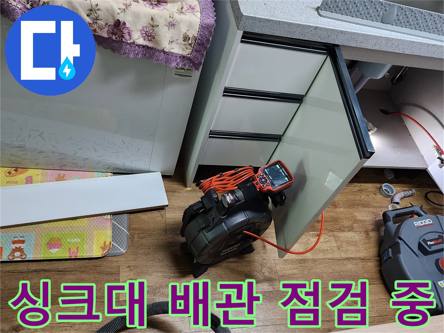 싱크대 하부장 내부의 누수 여부를 확인하기 위해 장비를 사용 중인 모습