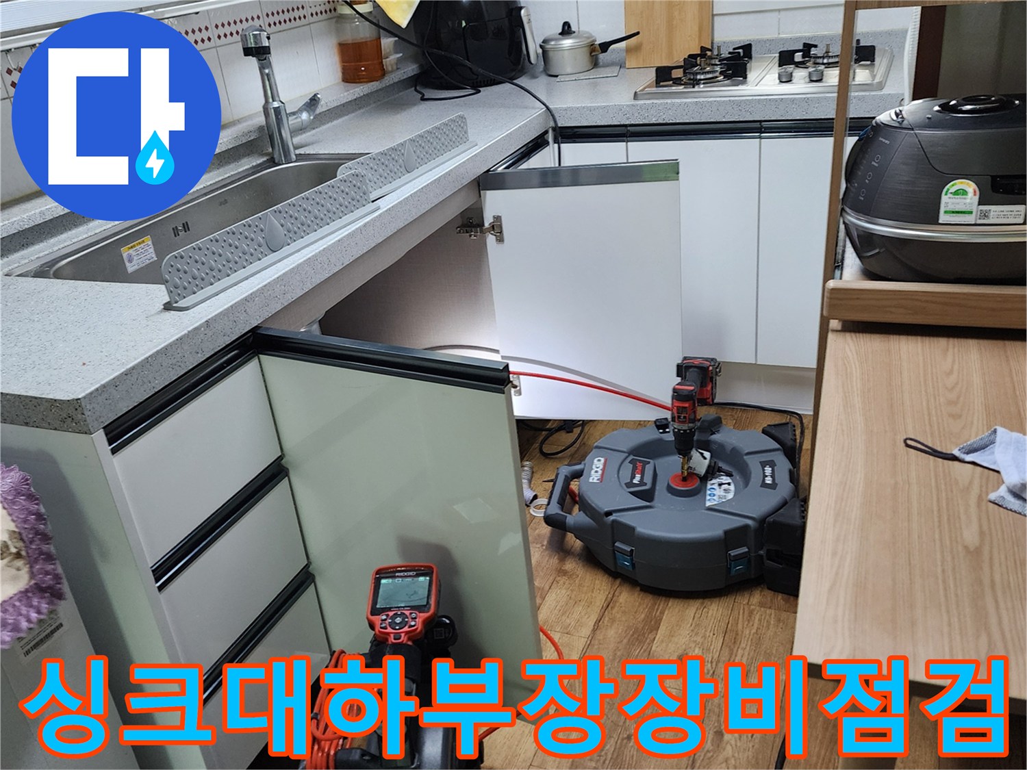 양주시 은현면-주방 싱크대 하부장에 배치된 누수 탐지 장비와 작업 도구들