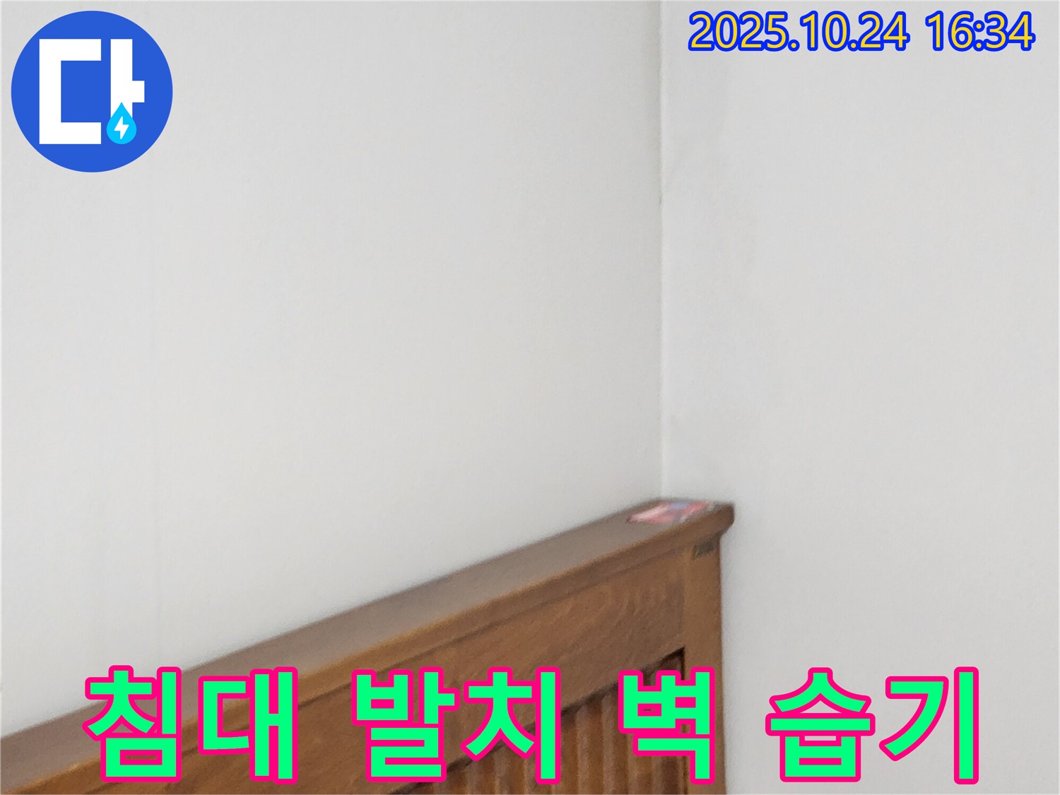 양주1동 봉우로 누수 현장 - 침대 발치 벽 누수로 인한 습기를 제거하는 누수 전문가의 습기 제거 작업