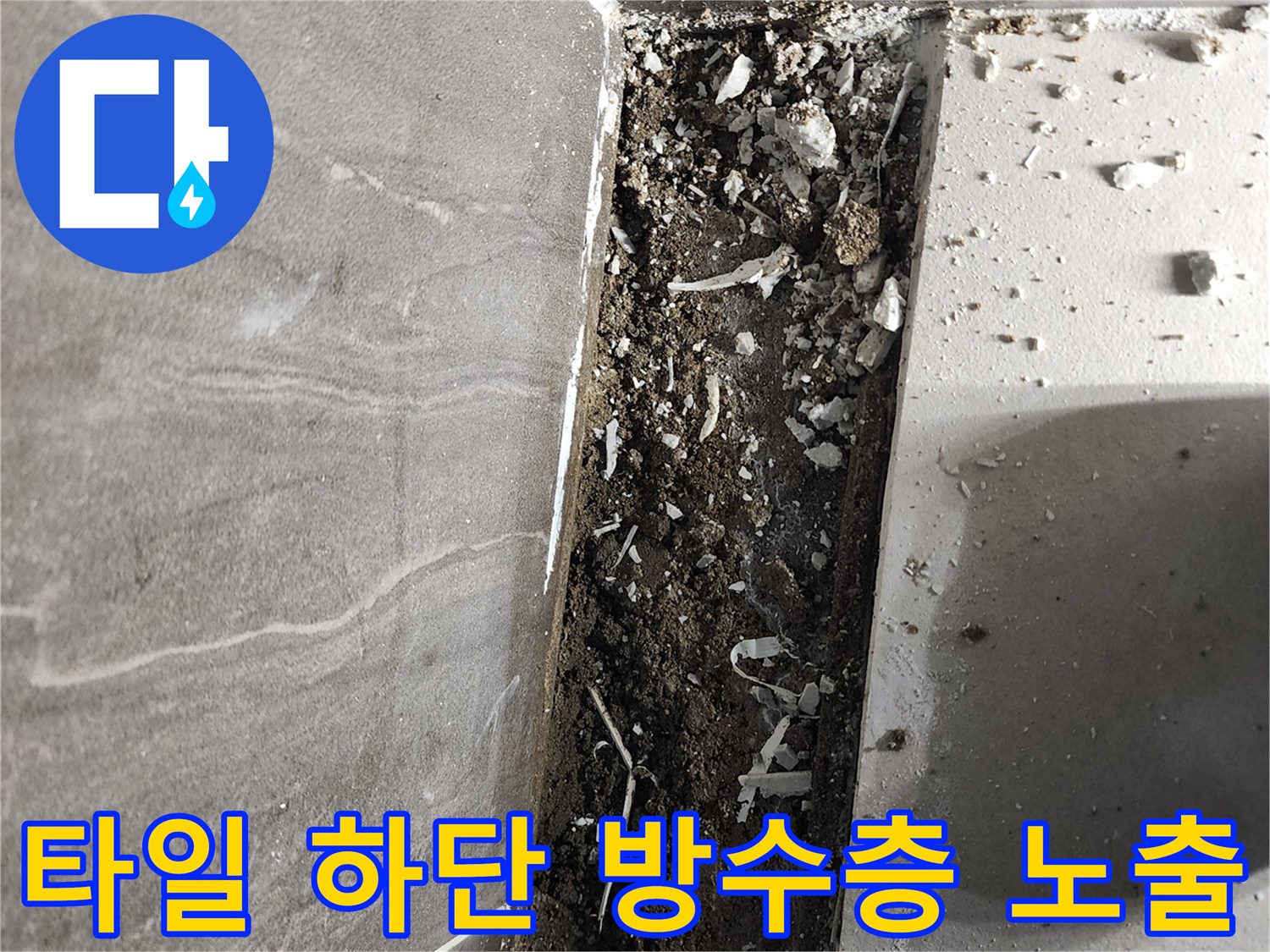 욕실 바닥 타일과 배수구 사이의 벌어진 틈새와 오염된 내부 자재를 촬영한 이미지입니다.