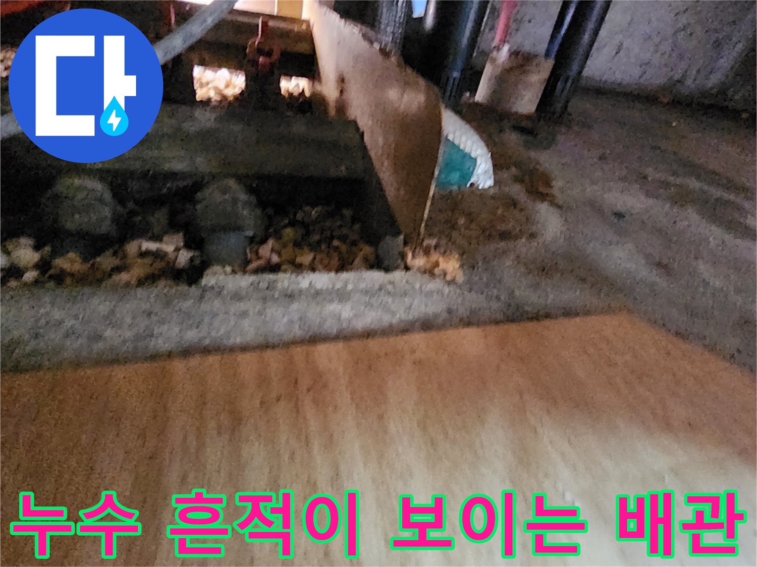 주방 하부 배관 주변의 젖은 자갈과 습기 상태 사진