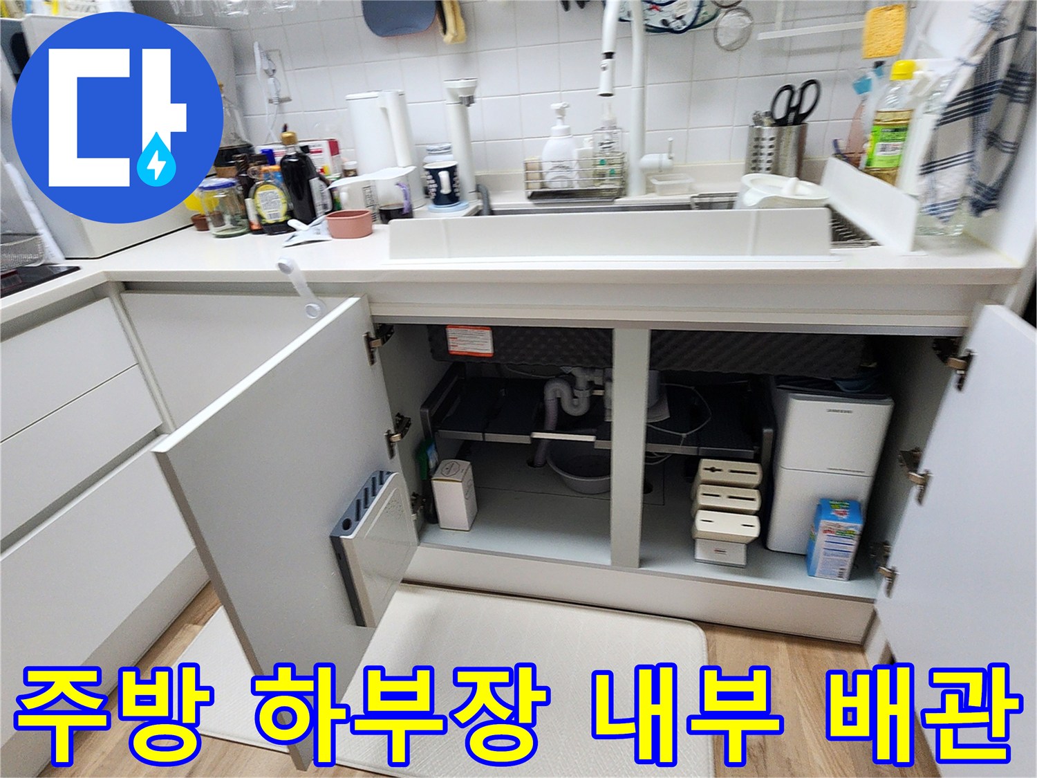싱크대 아래쪽 배관과 매립함 부근을 확인하기 위해 열어둔 하부장 모습입니다.