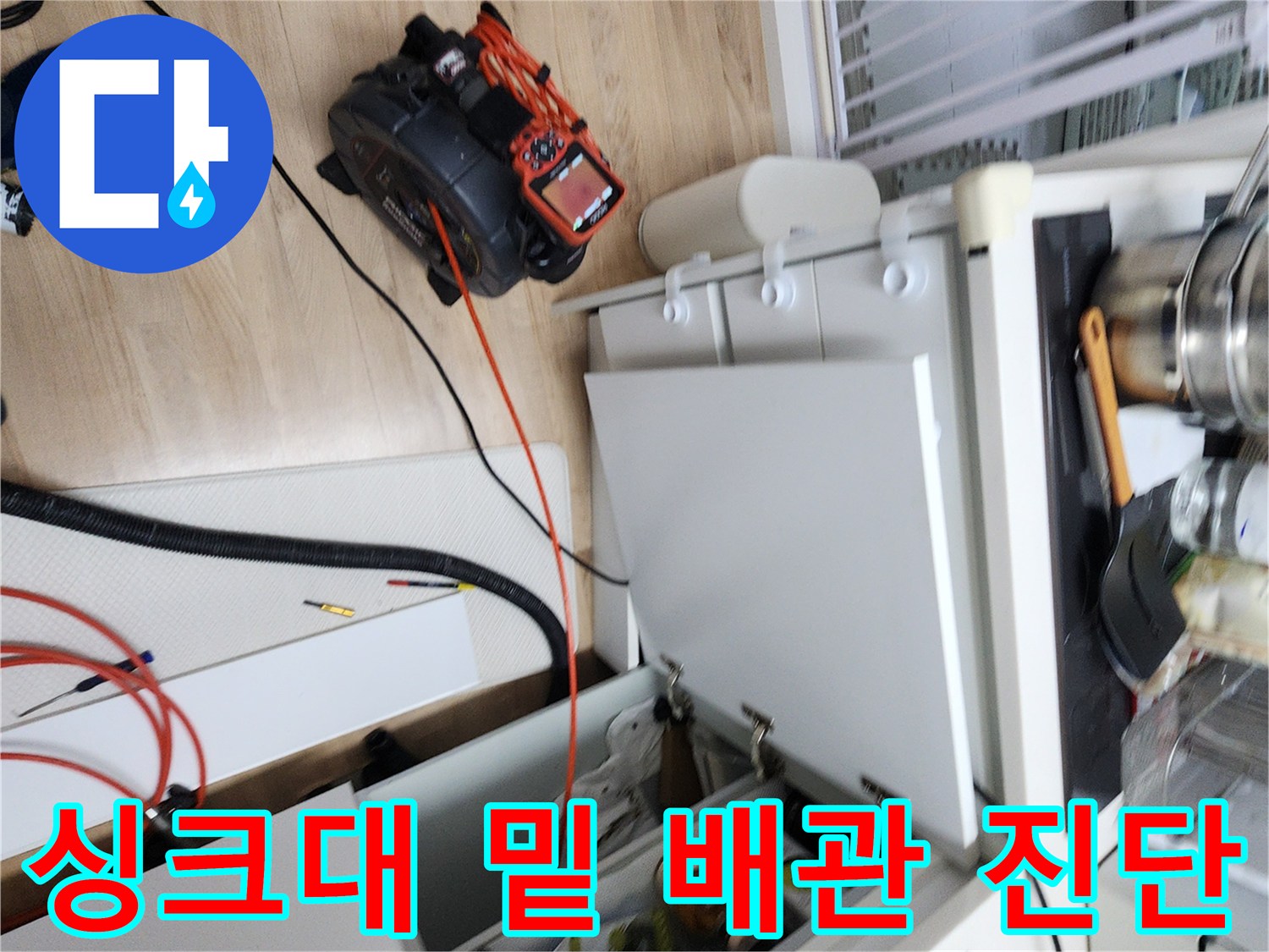 싱크대 아래쪽 젖은 바닥과 연결된 배관의 모습