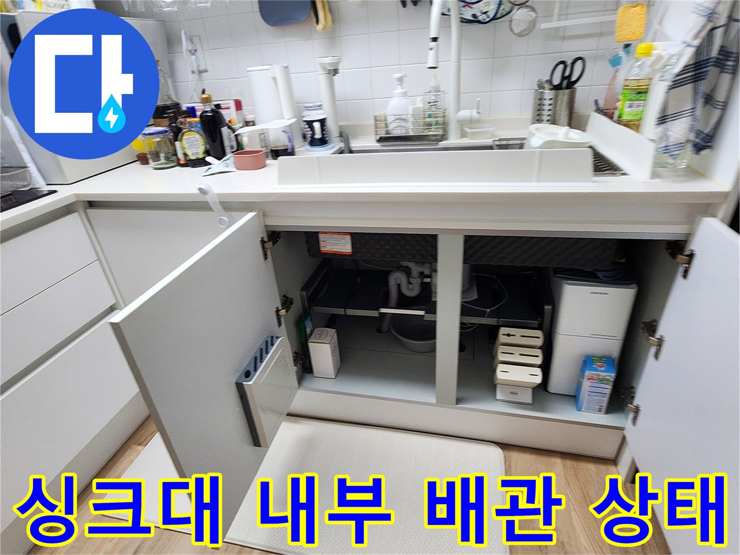 싱크대 하부장 문을 열고 확인한 내부 배관 및 매립함 구조물