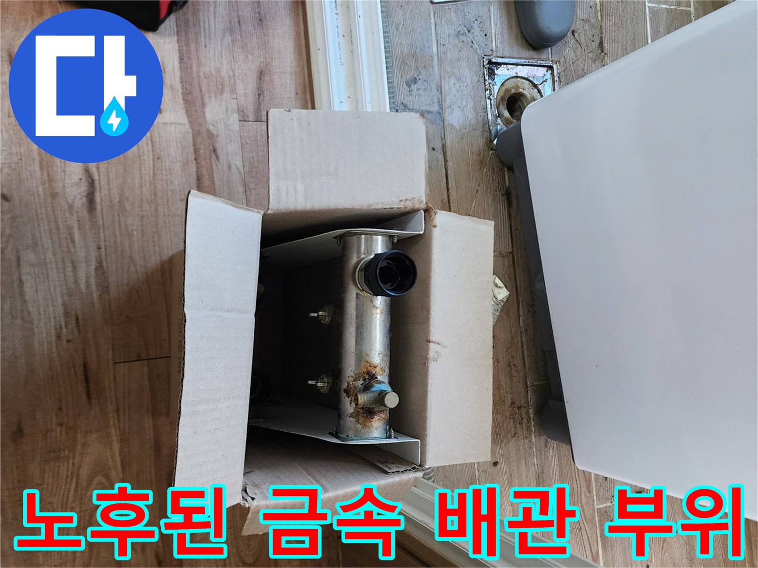 상자 속에 놓인 녹슬고 부식된 금속 배관의 모습입니다.