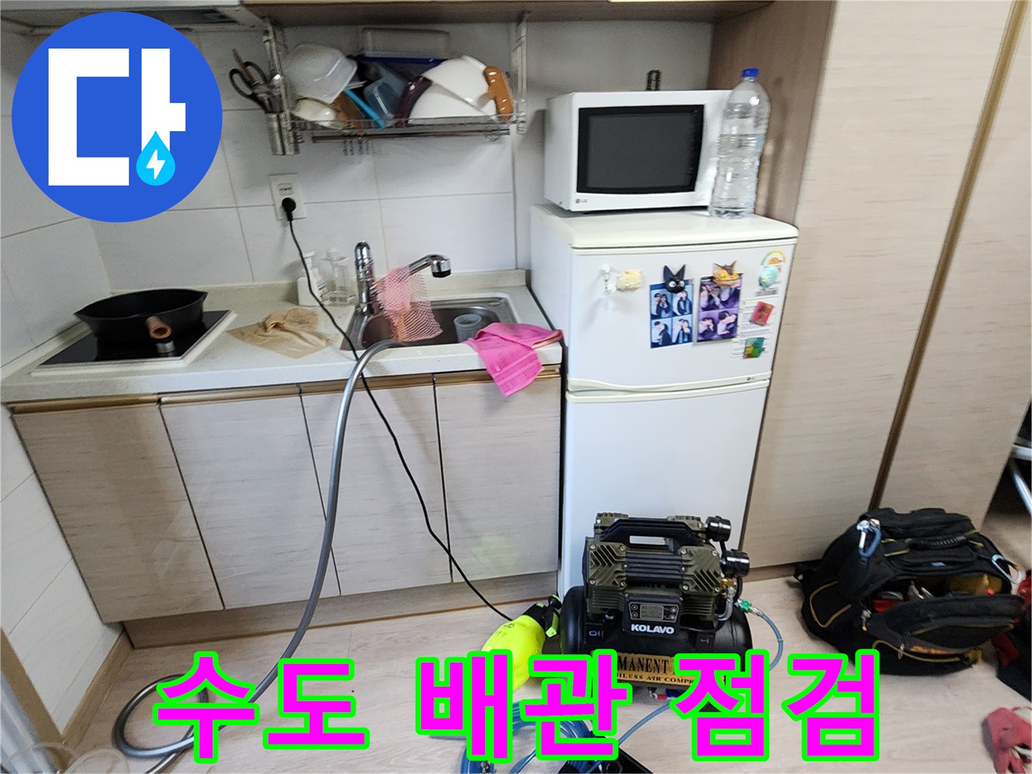싱크대 하단부 배관 누수를 찾기 위해 배치된 콤프레샤와 측정 호스