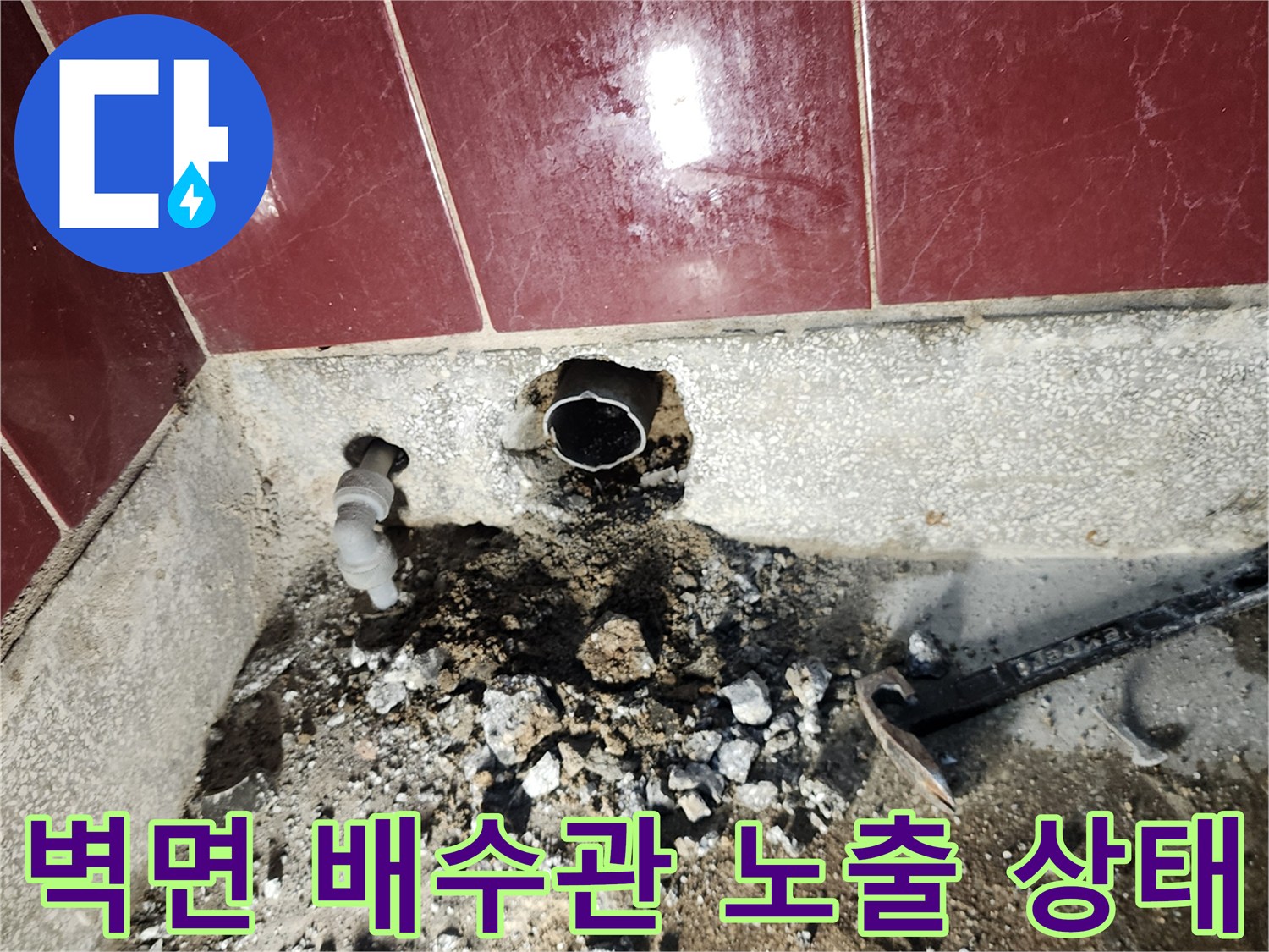 싱크대 하단 벽면을 굴착하여 드러난 배수관과 주변 파쇄된 시멘트