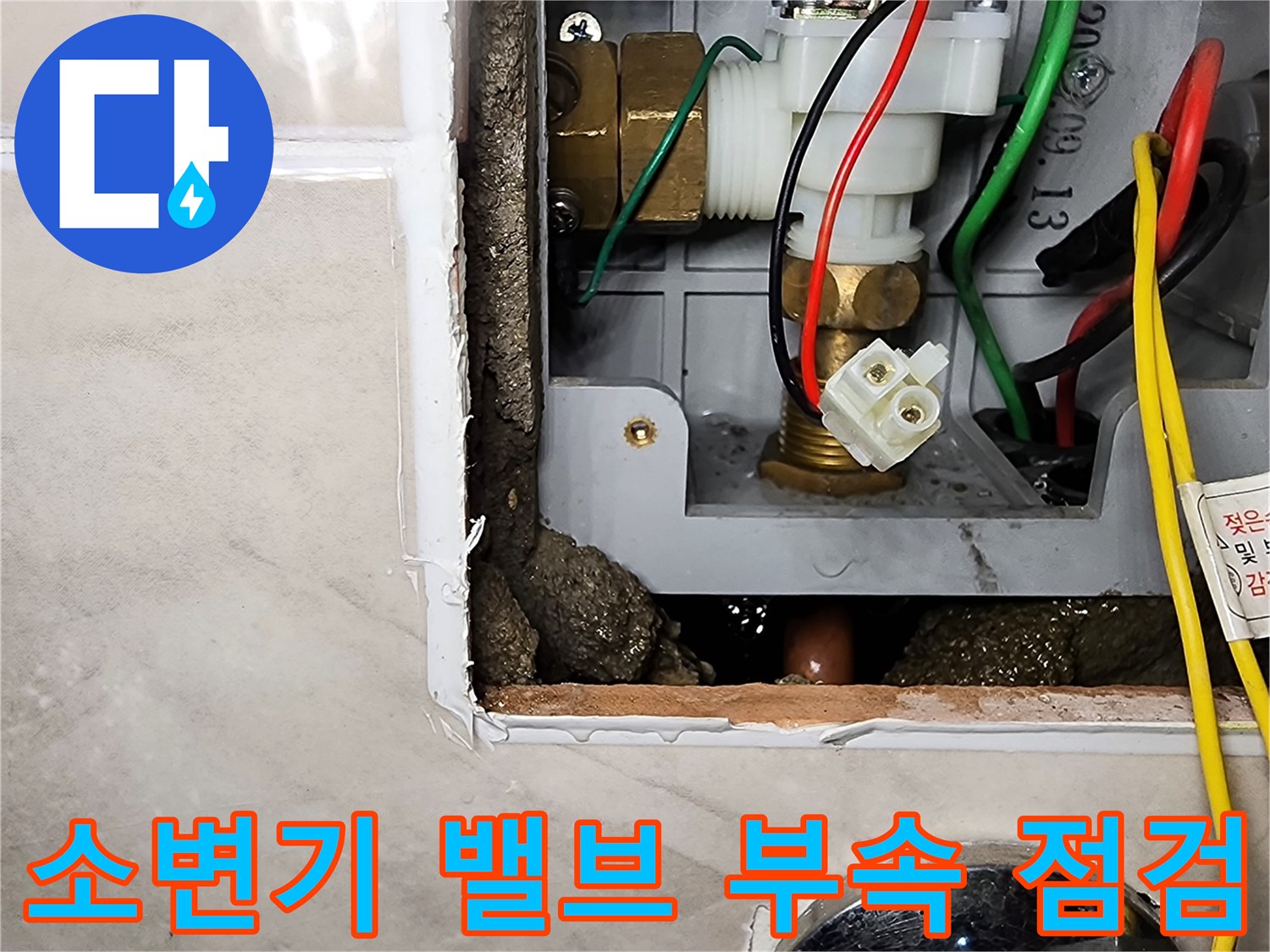 타일 제거 후 나타난 소변기 내부의 급수 장치와 연결된 배관들의 모습입니다.