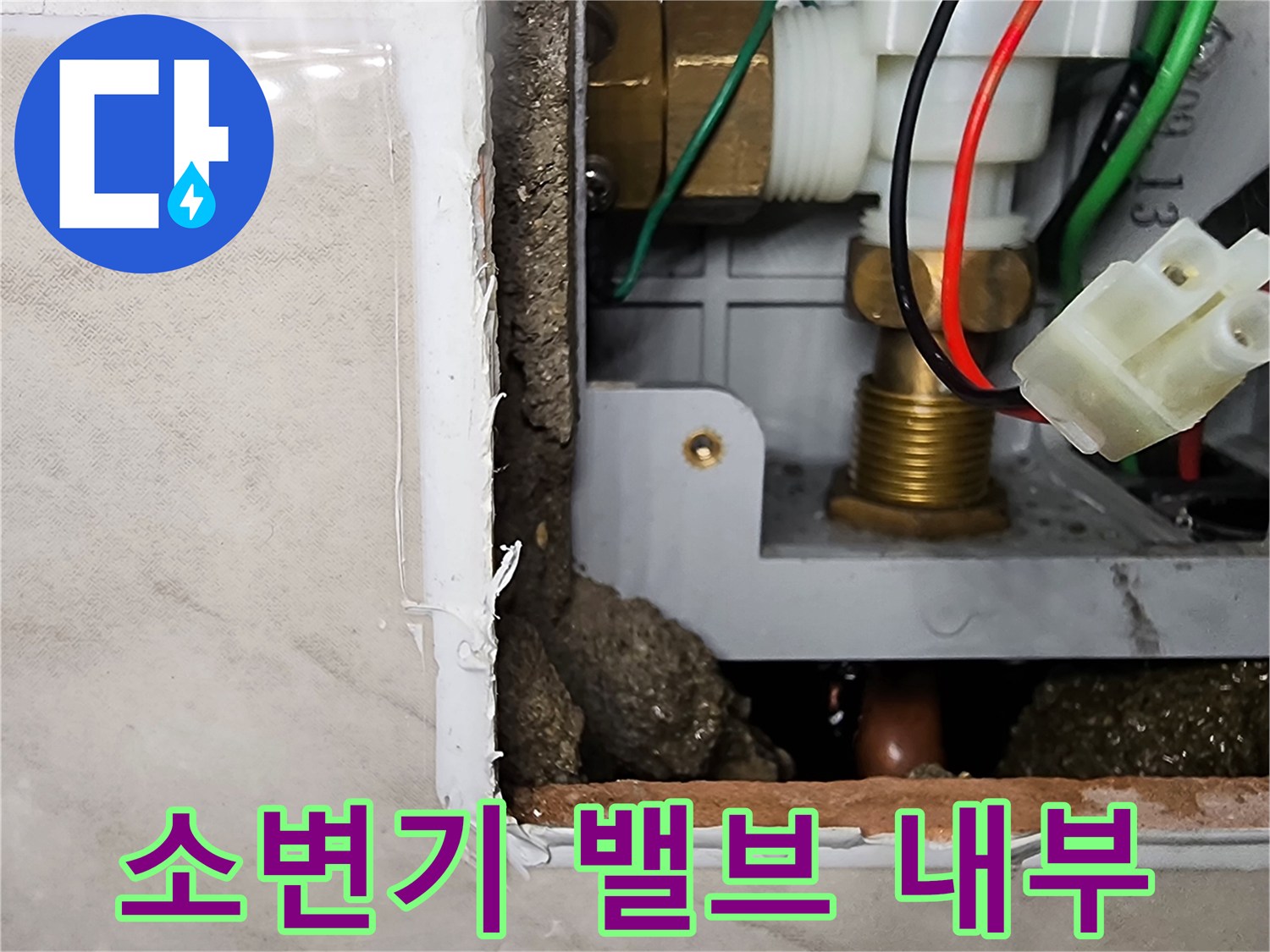 타일 제거 후 드러난 소변기 자동 세척 밸브와 급수 배관 연결 부위