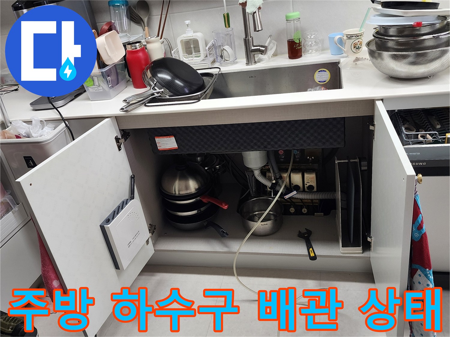 싱크대 하부장 내부의 노후된 배수 호스와 연결 부위 상세 사진