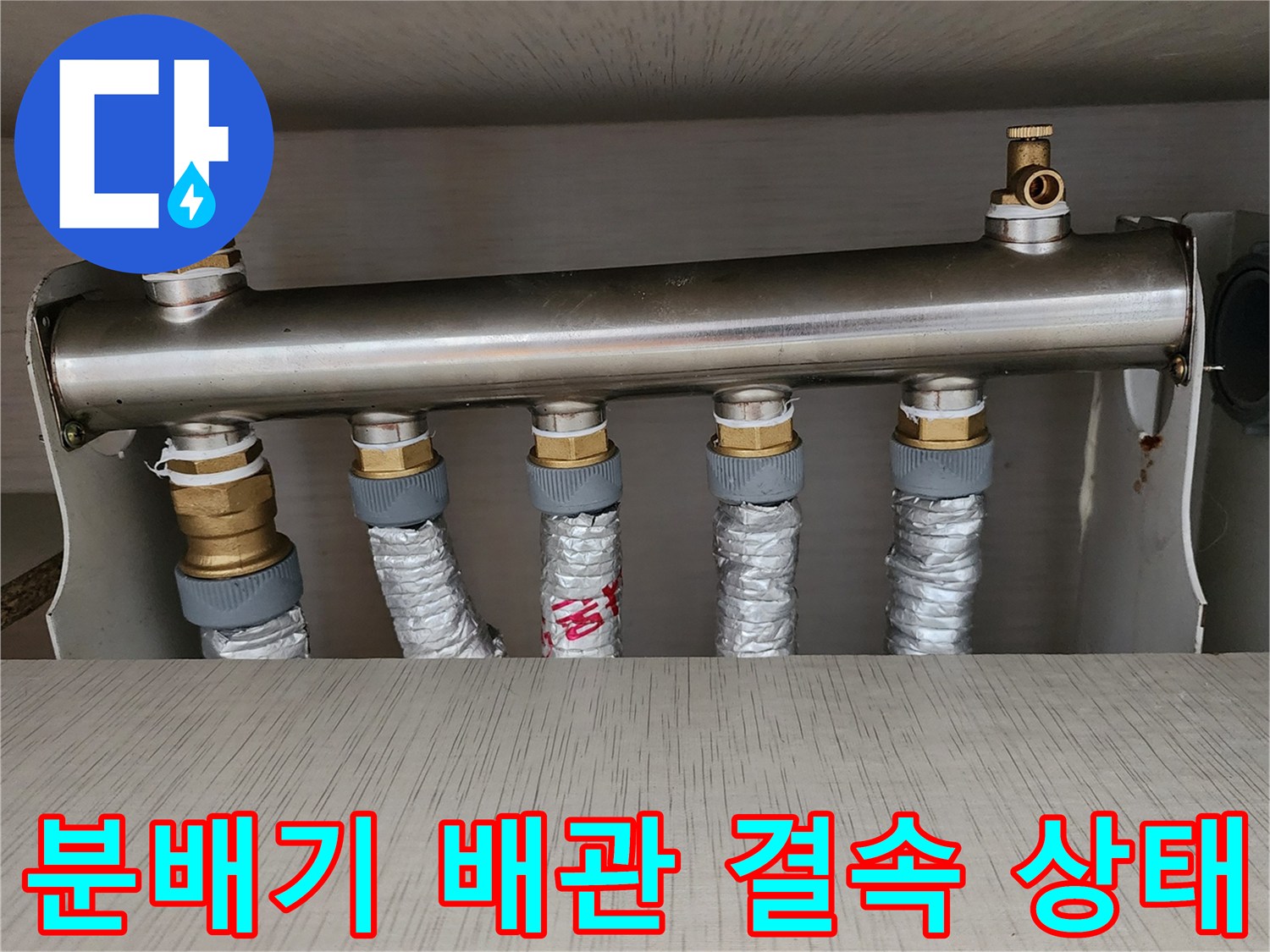 금속 재질의 분배기 본체와 보온재로 마감된 하단 배관들