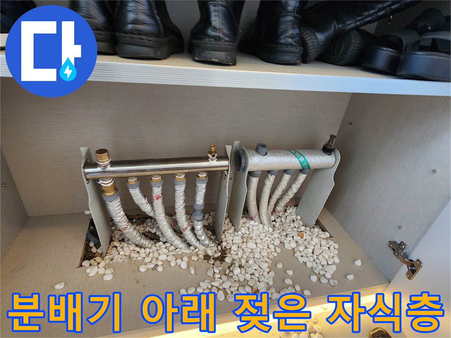 물에 젖어 있는 분배기 하부의 자갈과 배관 사진입니다.