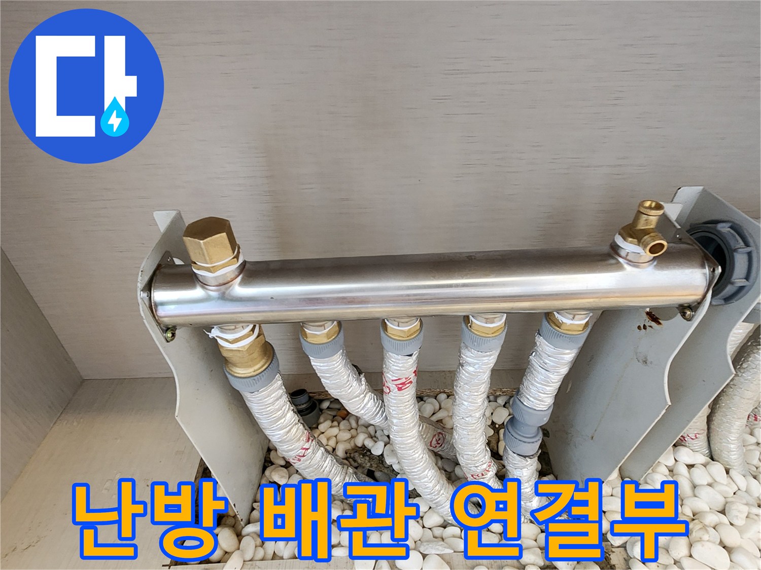 은색 금속 분배기와 하단으로 뻗어나간 보온 배관