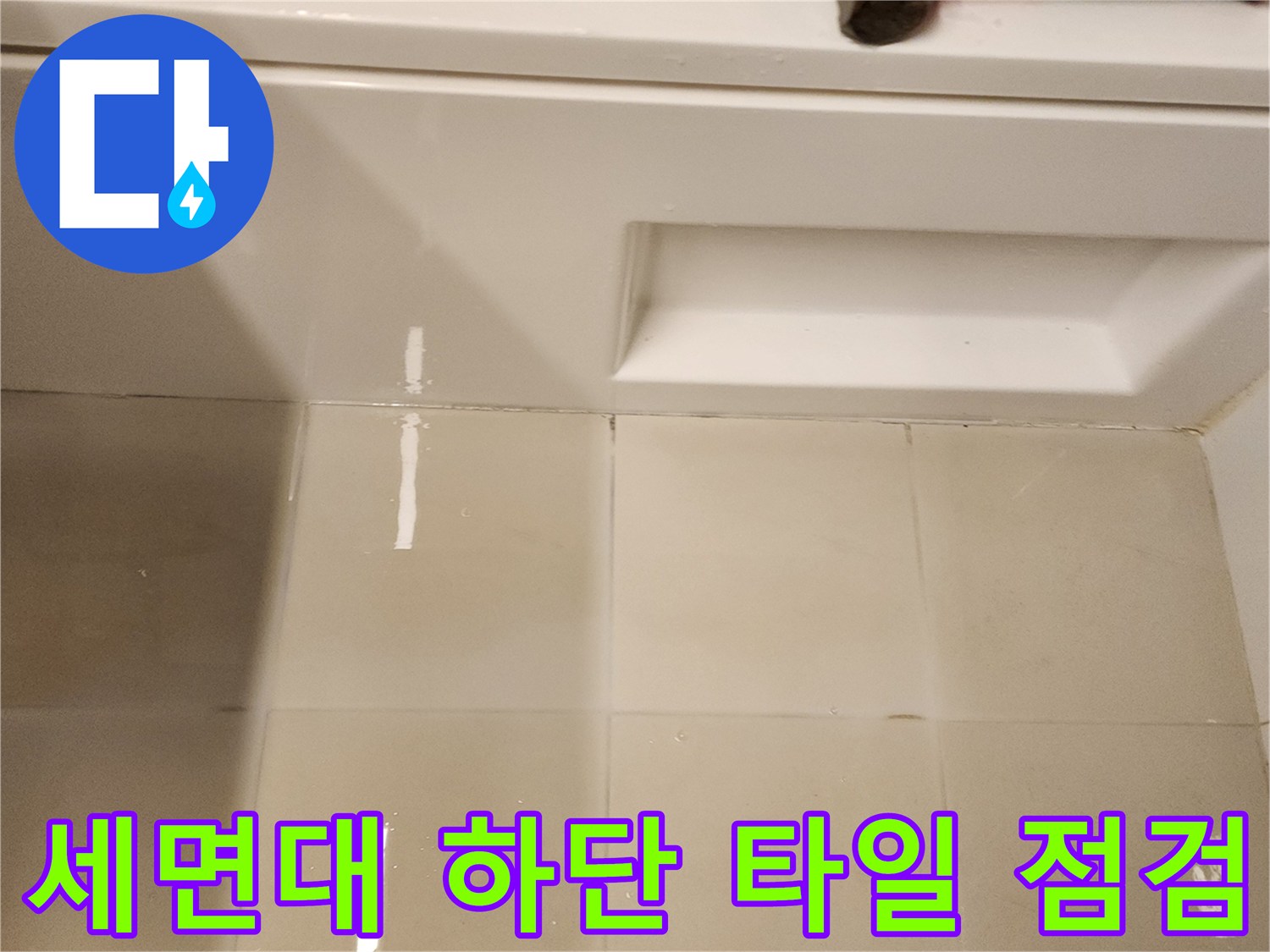 세면대 선반 아래 타일 면과 망치가 놓인 작업 현장