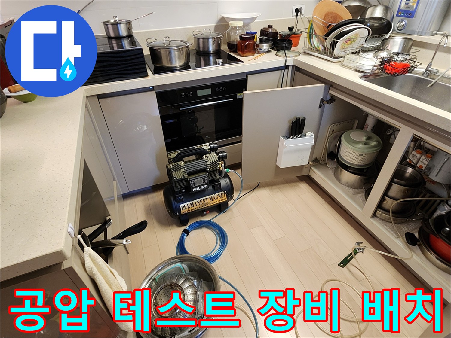 싱크대 하부 공간에 설치된 누수 탐지용 콤프레셔와 호스
