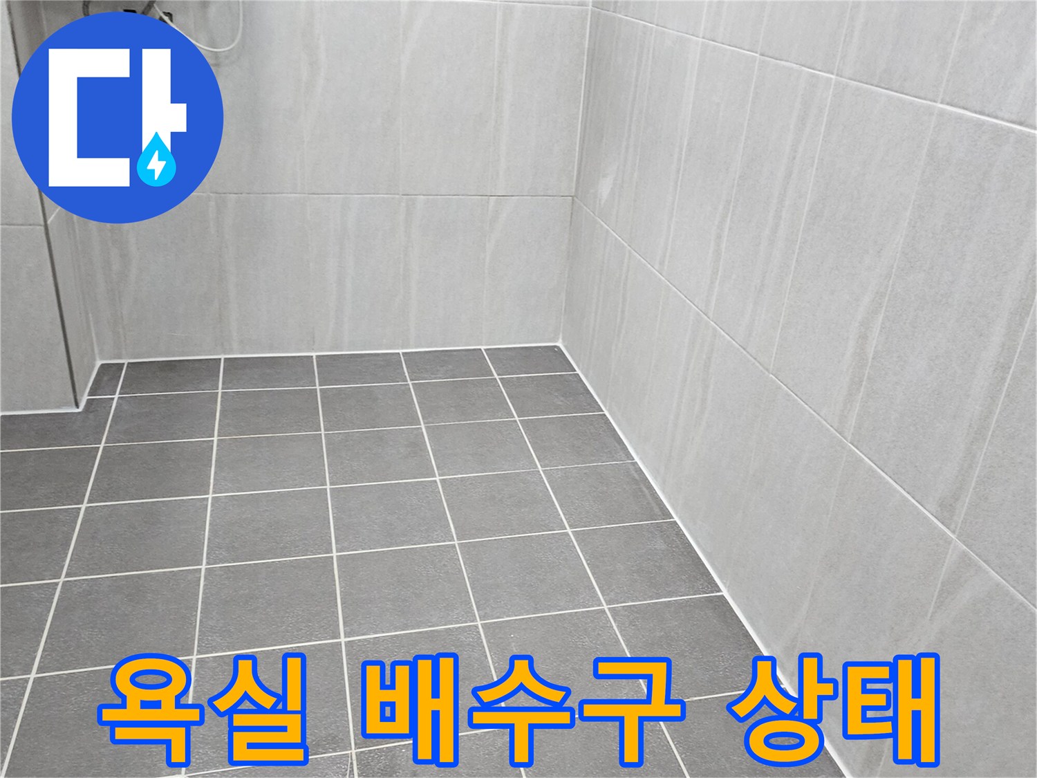 욕실 바닥 배수구 주변의 타일 줄눈과 유가 상태를 촬영한 사진입니다.