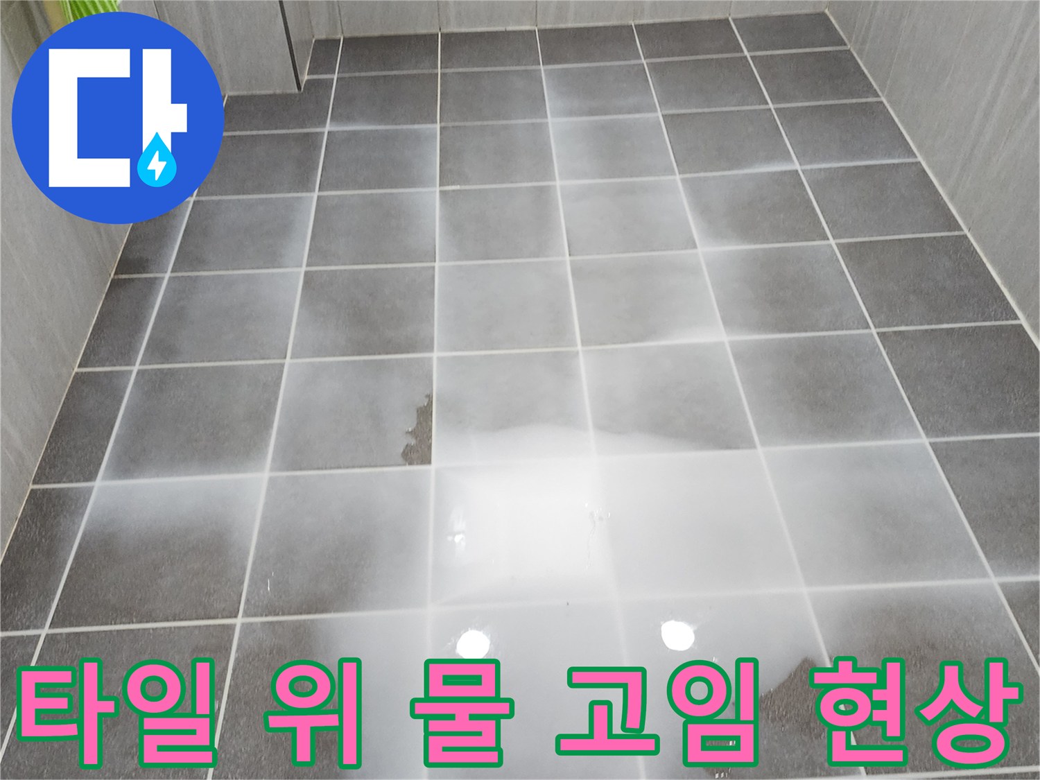 짙은 회색 타일 위에 물이 찰랑거리게 고여 있는 사진입니다.