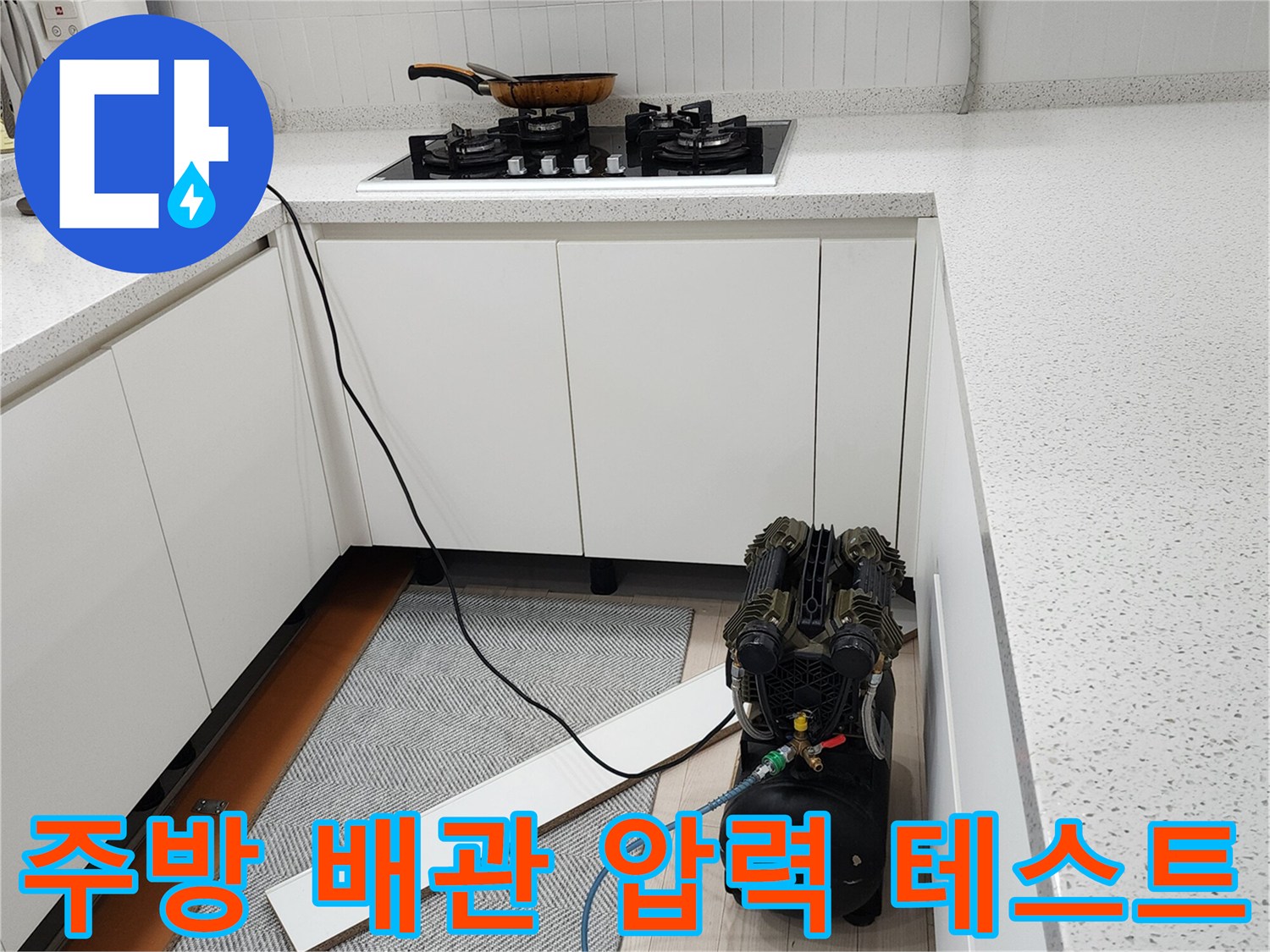 주방 싱크대 하부 공간에서 진행되는 공압 테스트 장비 설치 모습