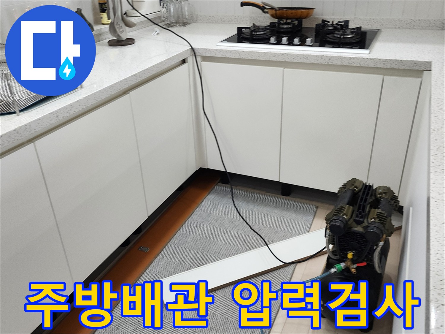 주방 싱크대 하부장에 설치된 공압 테스트용 컴프레서와 배관 연결 모습