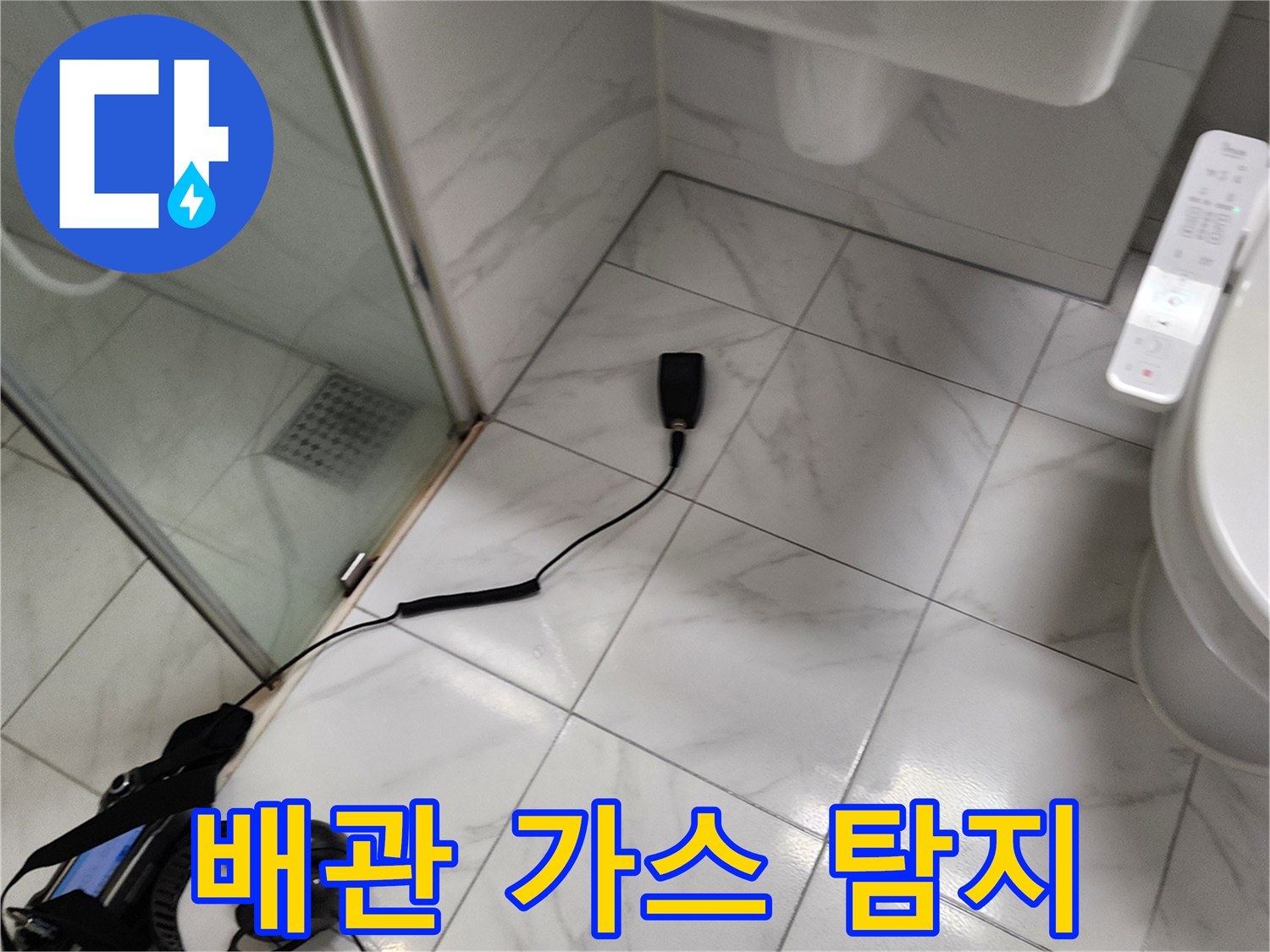 화장실 바닥에서 배관 누수를 찾기 위해 가스 탐지기를 연결한 모습입니다.