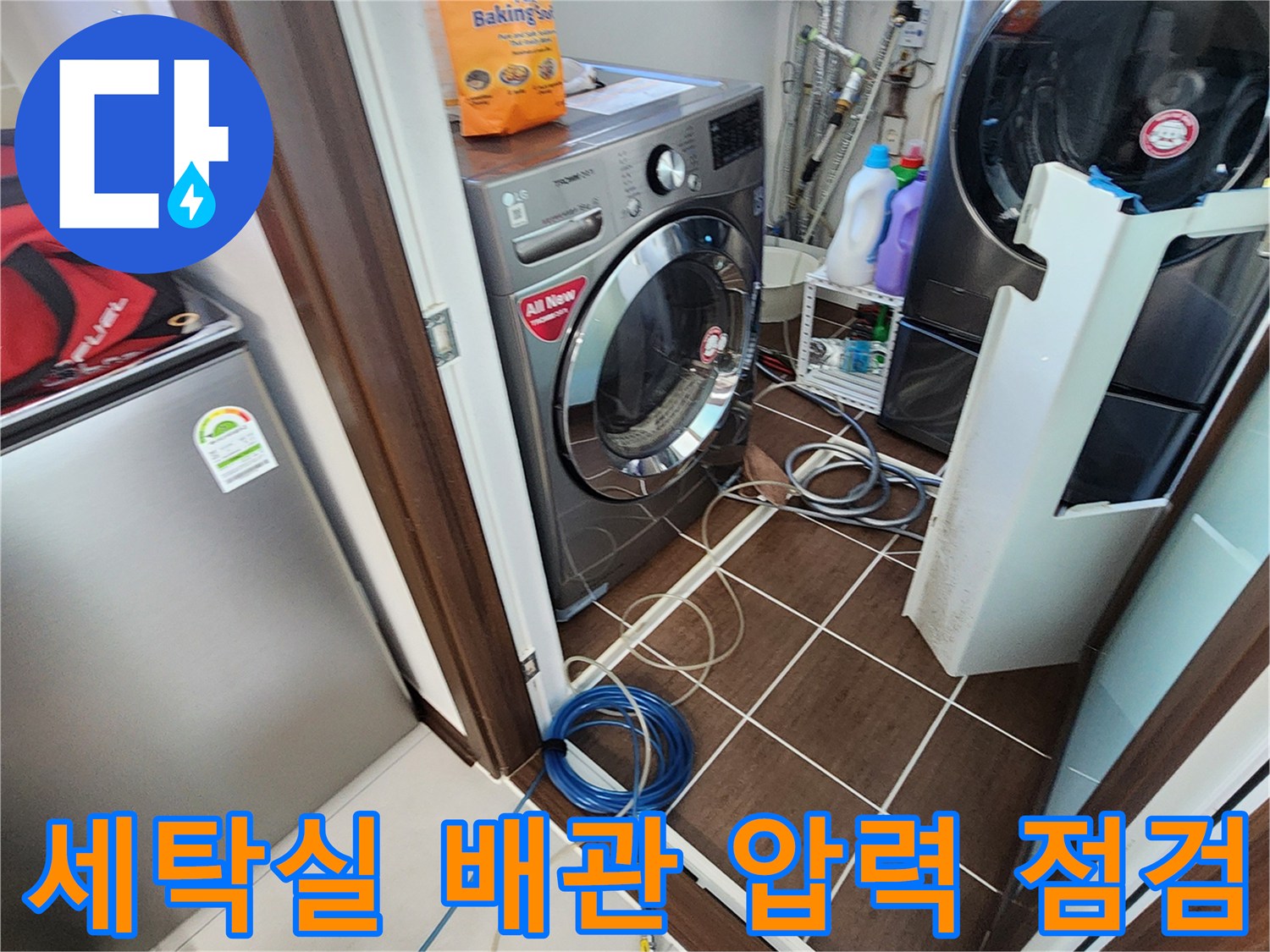 세탁기와 건조기가 있는 다용도실 바닥에 가스 탐지 호스와 압력계가 연결된 모습