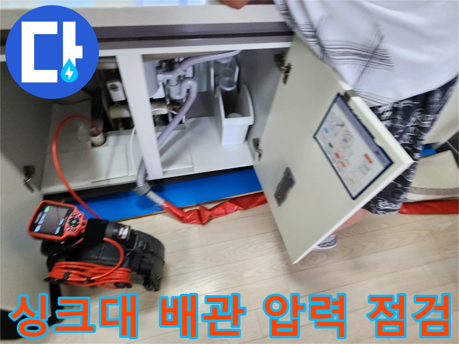 싱크대-아래쪽-배관-주변의-상태를-측정기로-면밀히-조사하는-모습