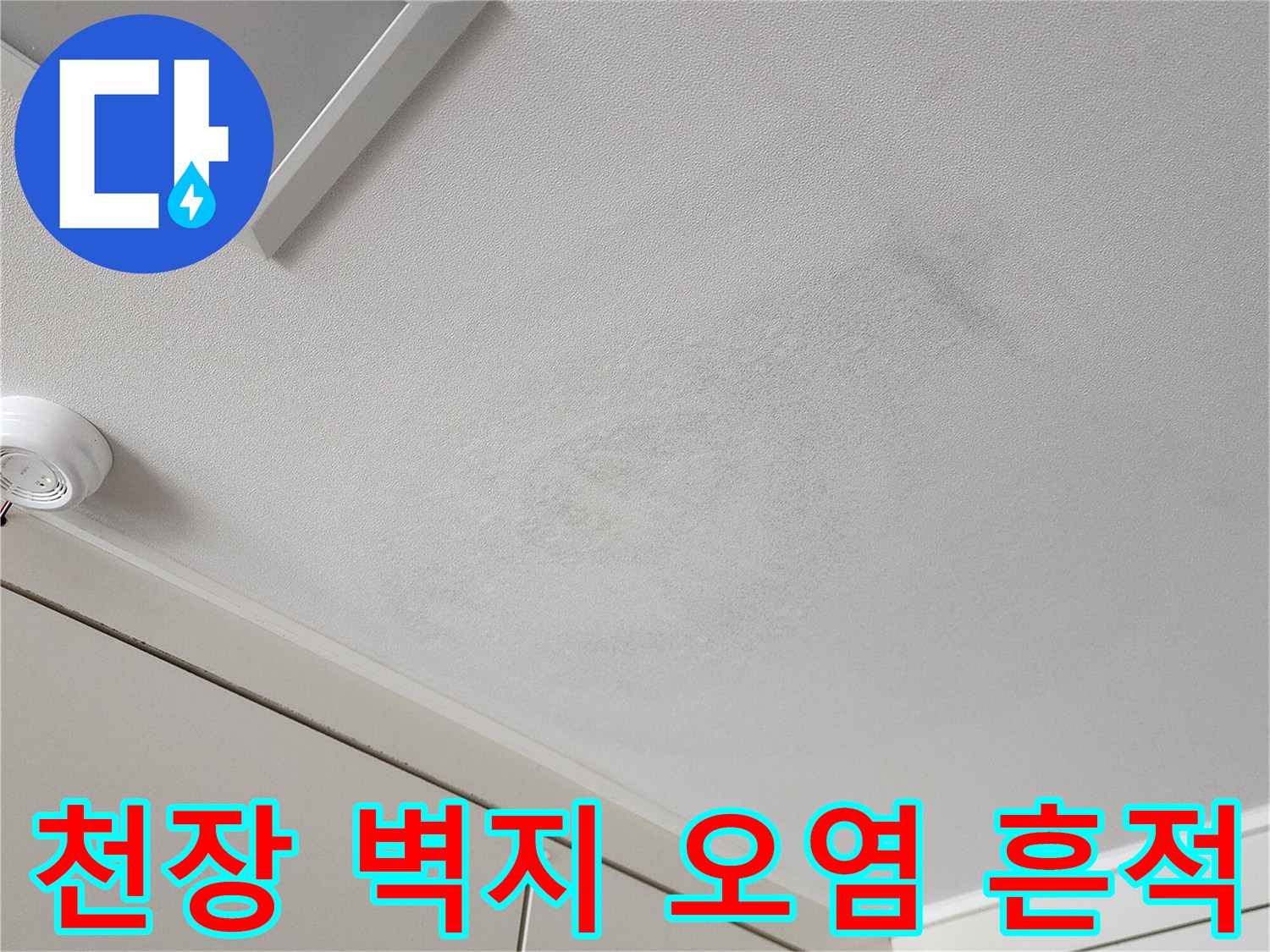 천장 상단에 나타난-어두운 얼룩과 변색된 벽지 모습입니다.