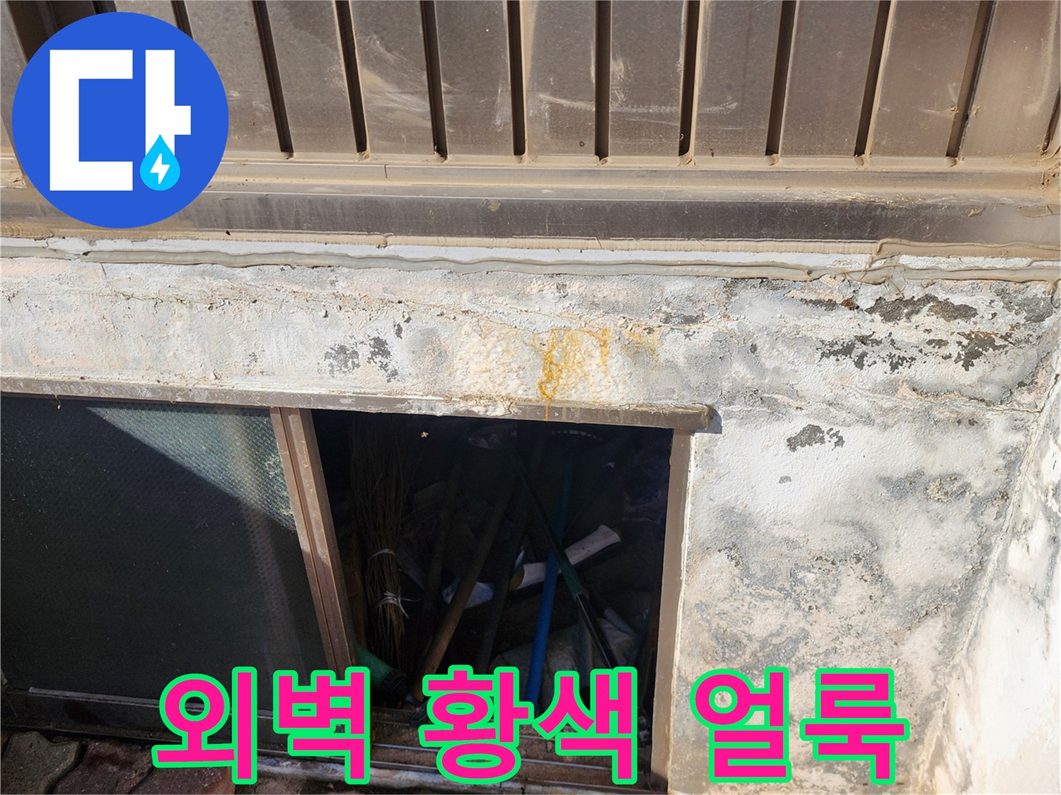 건물 외벽 하단부에 발생한 노란색 변색과 습기 흔적