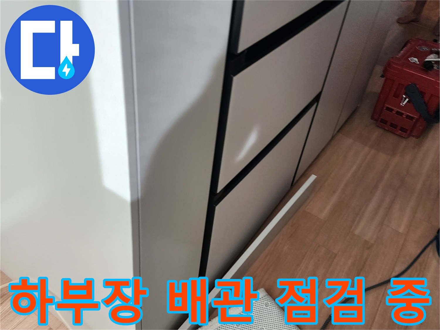 싱크대 하부 공간에 연결된 수도 배관과 압력 측정 호스