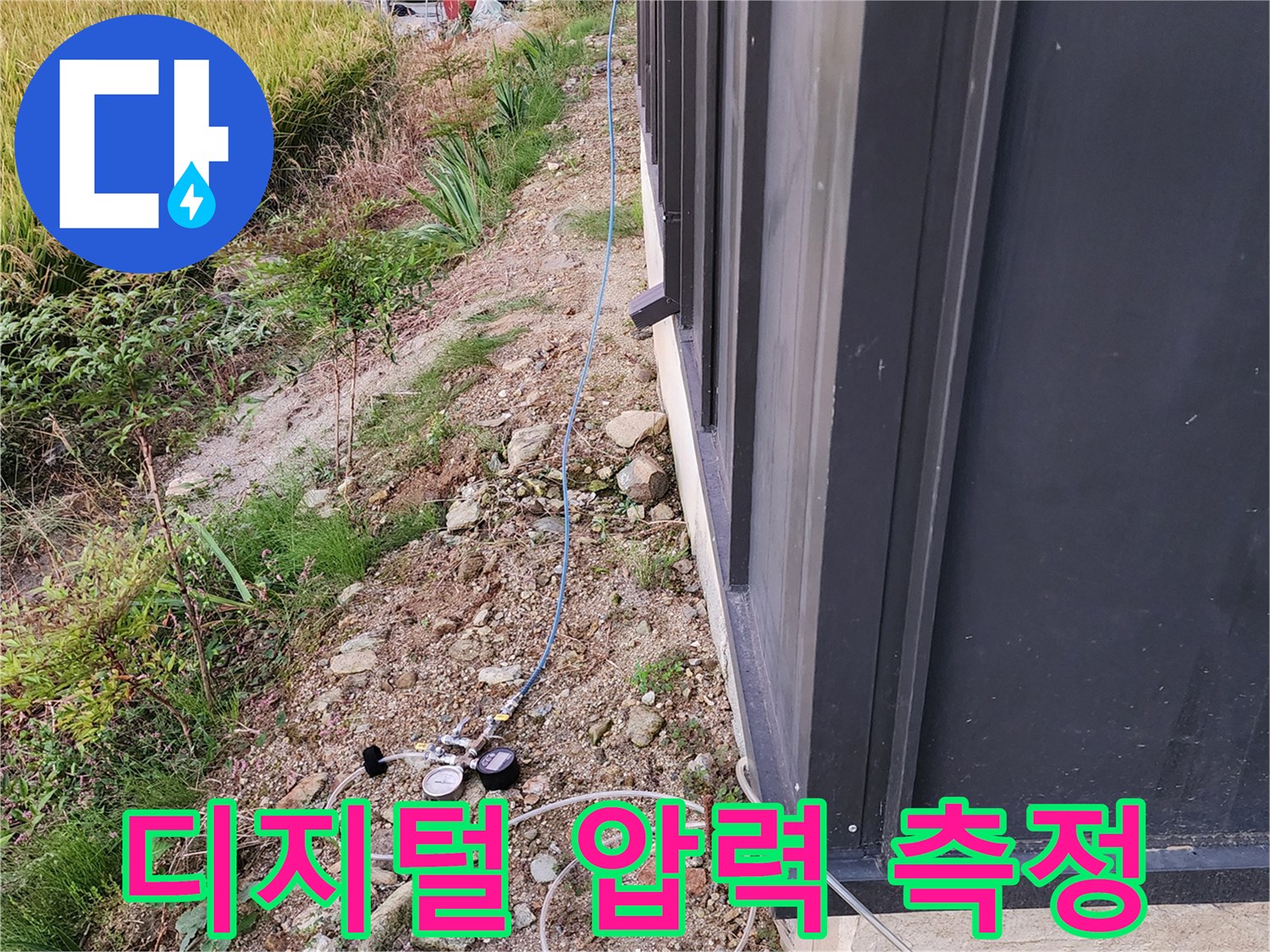 지면 근처 배관에 연결된 공압 테스트용 게이지와 호스 상세