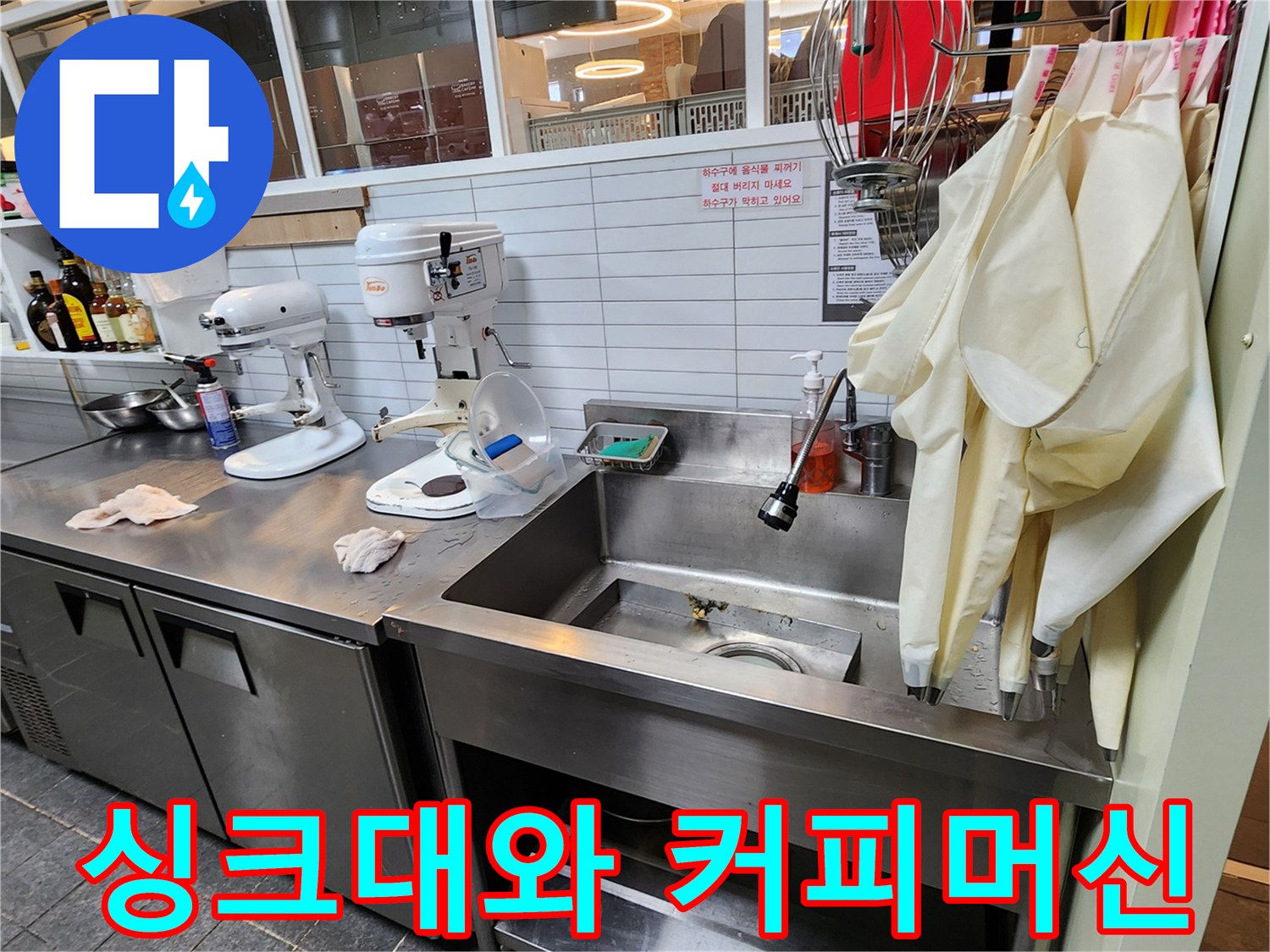 스테인리스 싱크대 옆에 배치된 카페용 커피 머신과 장비들 - 누수 점검 구역