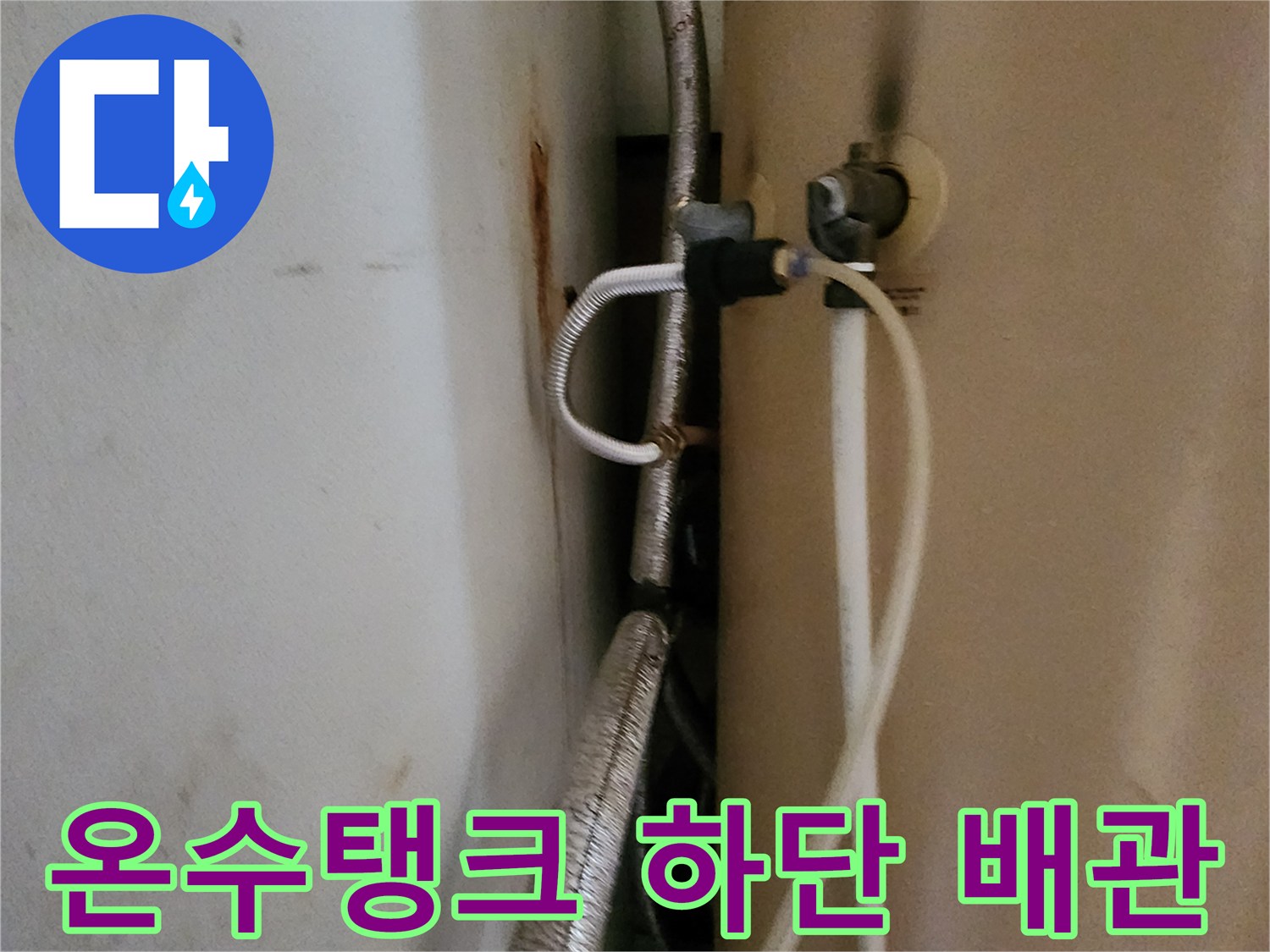 금속 주름관과 흰색 호스가 연결된 온수기 하단부