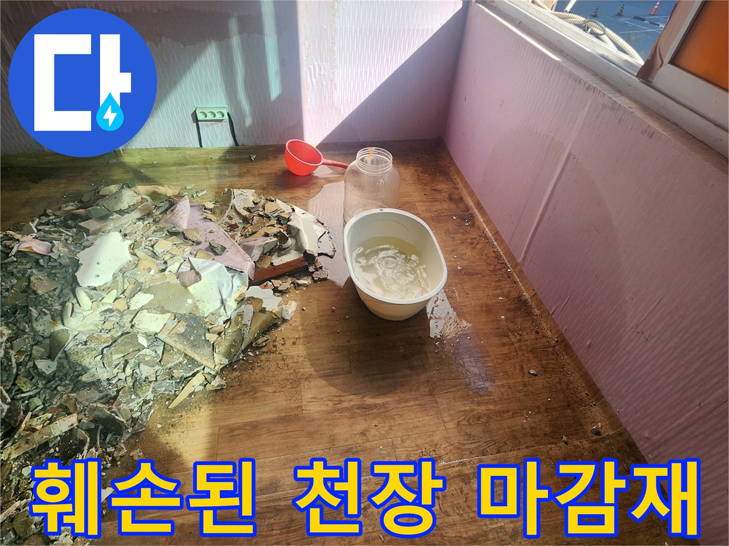 바닥에 떨어진 젖은 천장 자재와 물받이 용기