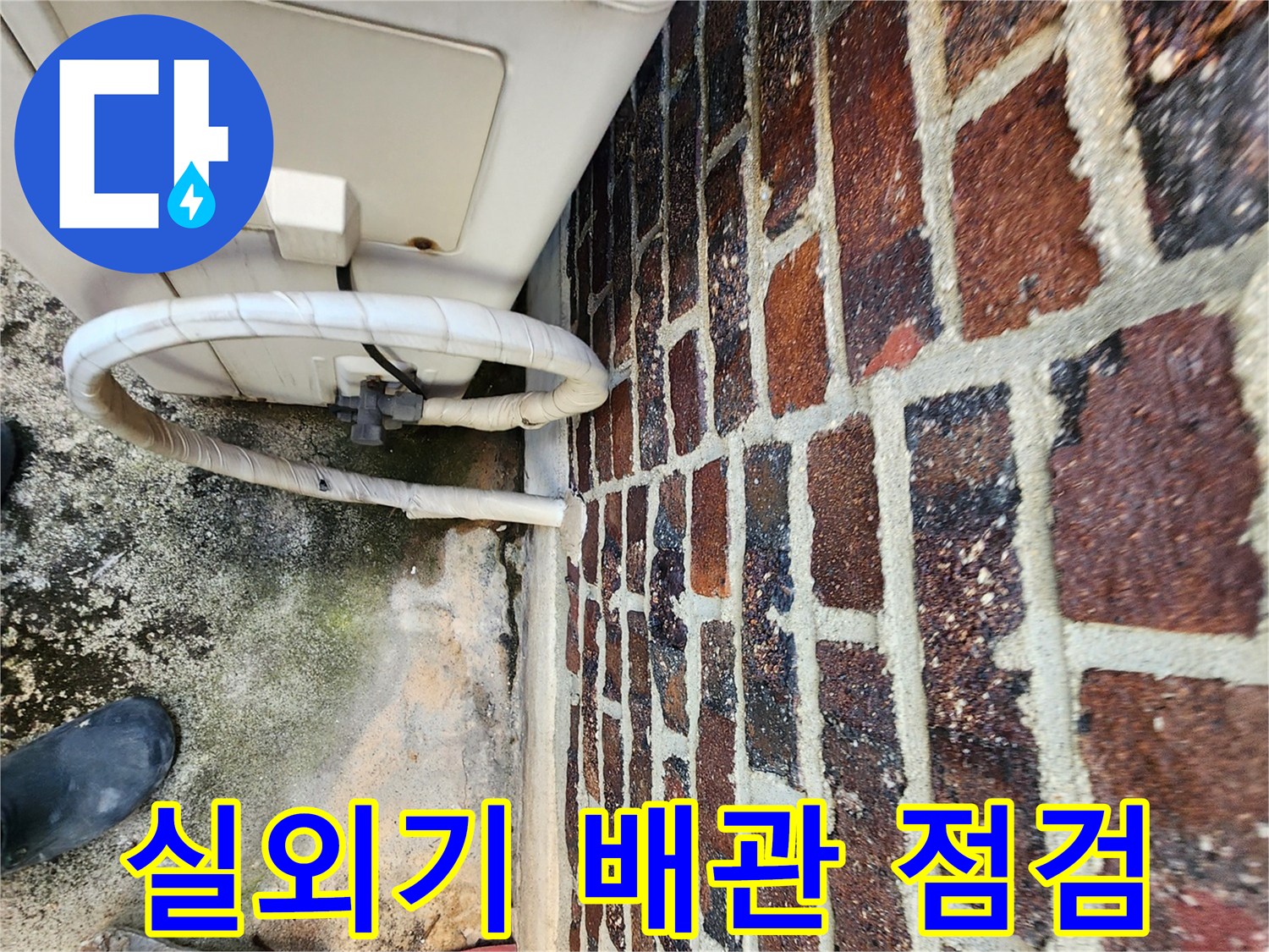 에어컨 실외기 연결 배관과 벽돌 벽면의 근접 촬영
