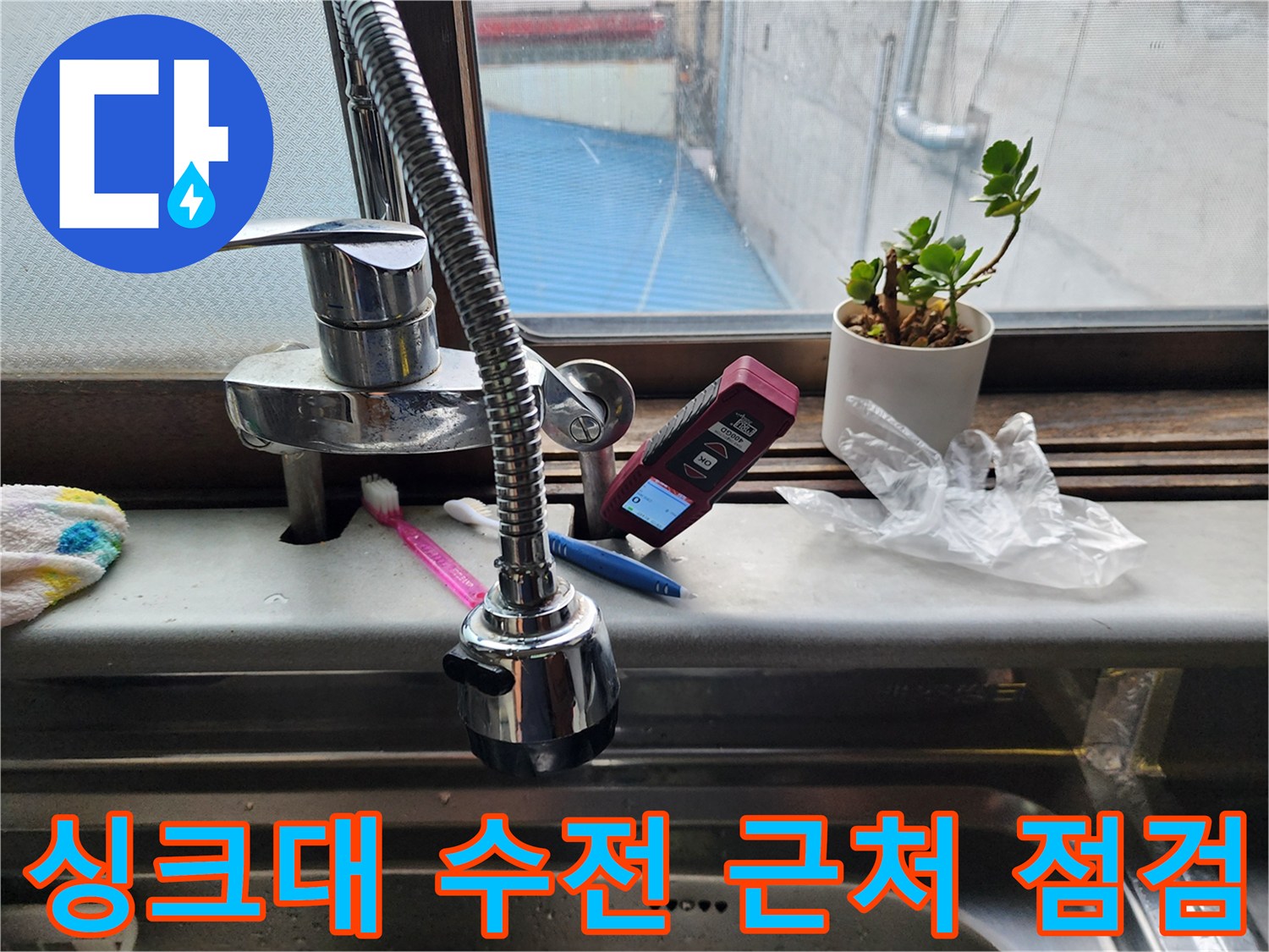 주방 싱크대 수전과 주변 소품이 놓인 모습