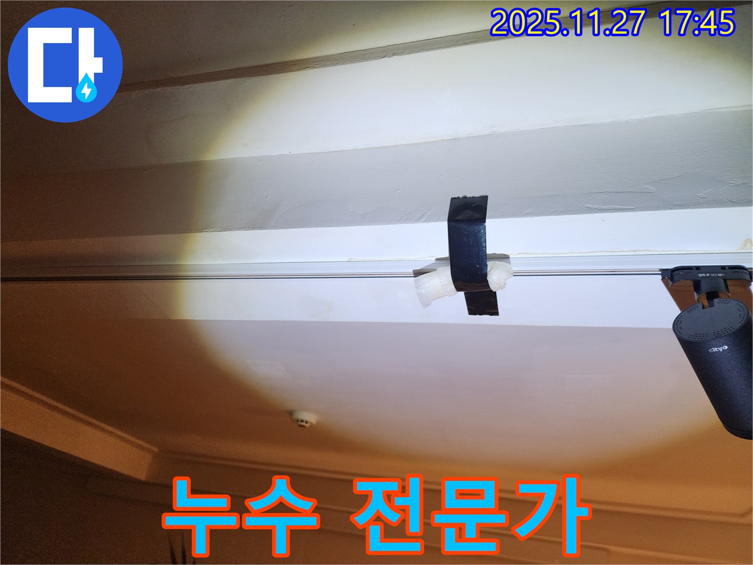 천장 누수 발생 시 임시 조치 - 테이프를 사용하여 물이 떨어지는 것을 막고 있는 모습 - 전문가의 손길 필요