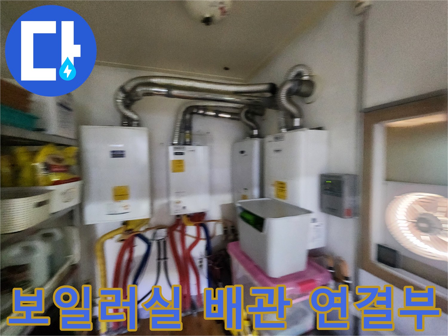보일러실 내부의 은색 연통과 다채로운 색상의 급수 및 온수 배관