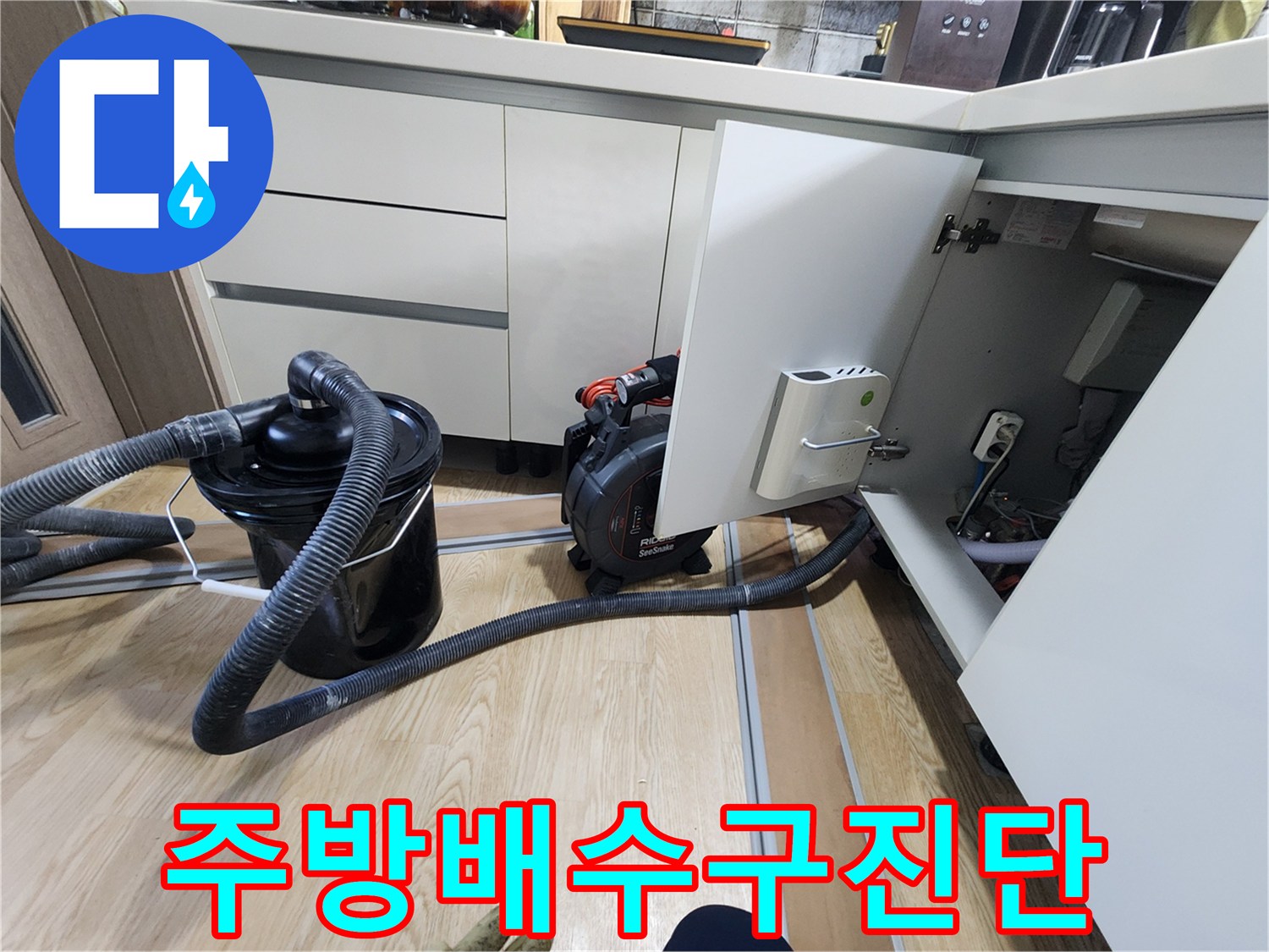 싱크대 아래쪽 하부장 내부의 배관 및 장비 배치 상태