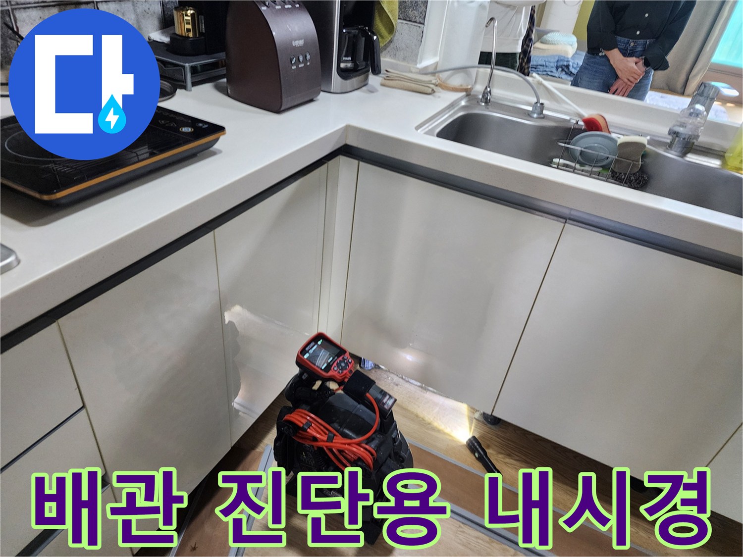 싱크대 하부 공간에서 작동 중인 배관 탐지용 카메라 장비