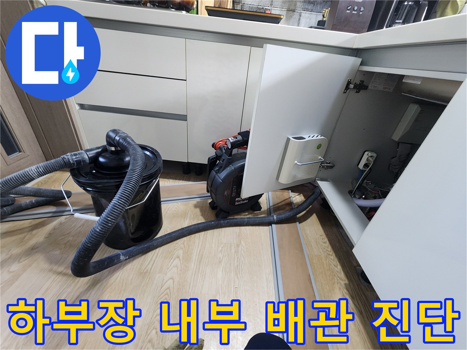 싱크대 하부 공간의 배관 부위를 장비로 정밀하게 조사하는 모습
