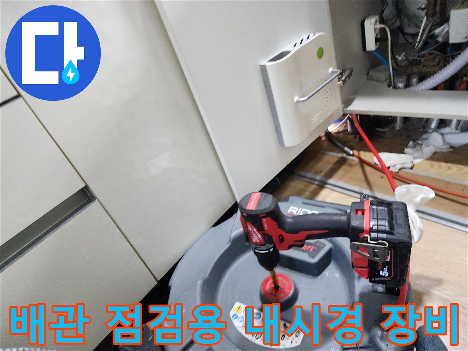 주방 싱크대 하부 공간에서 사용 중인 배관 내시경 카메라와 전동 드릴