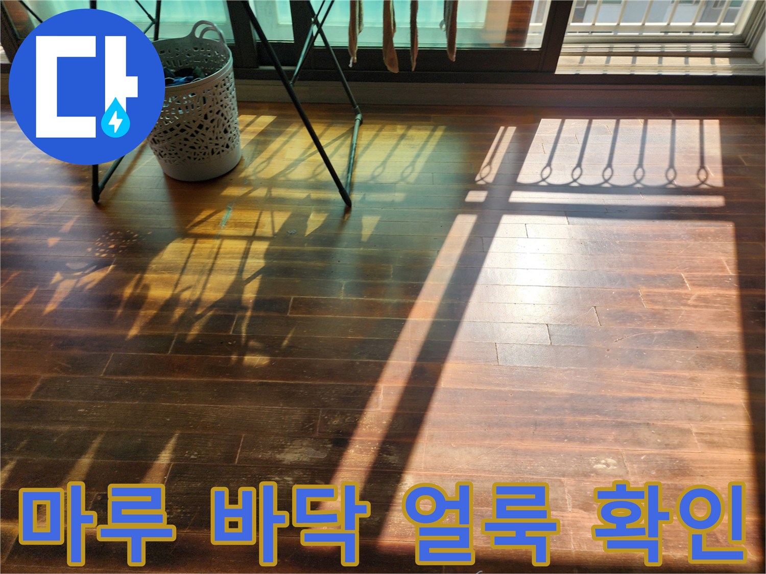 창가 근처 거실 마루의 변색된 얼룩 부위 사진