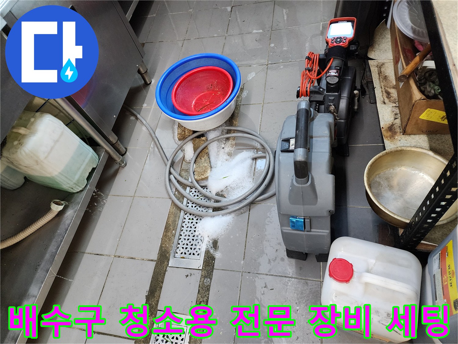 식당 주방 바닥 배수 트렌치 주변의 작업용 흡입기 및 도구들