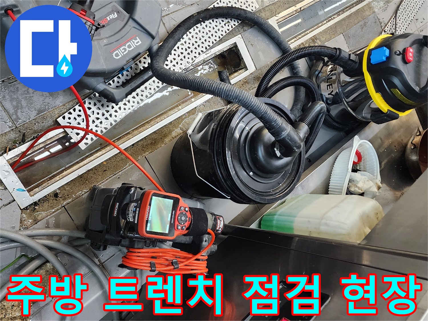 식당 주방 트렌치 주변에 배치된 배관 진단 장비와 청소기