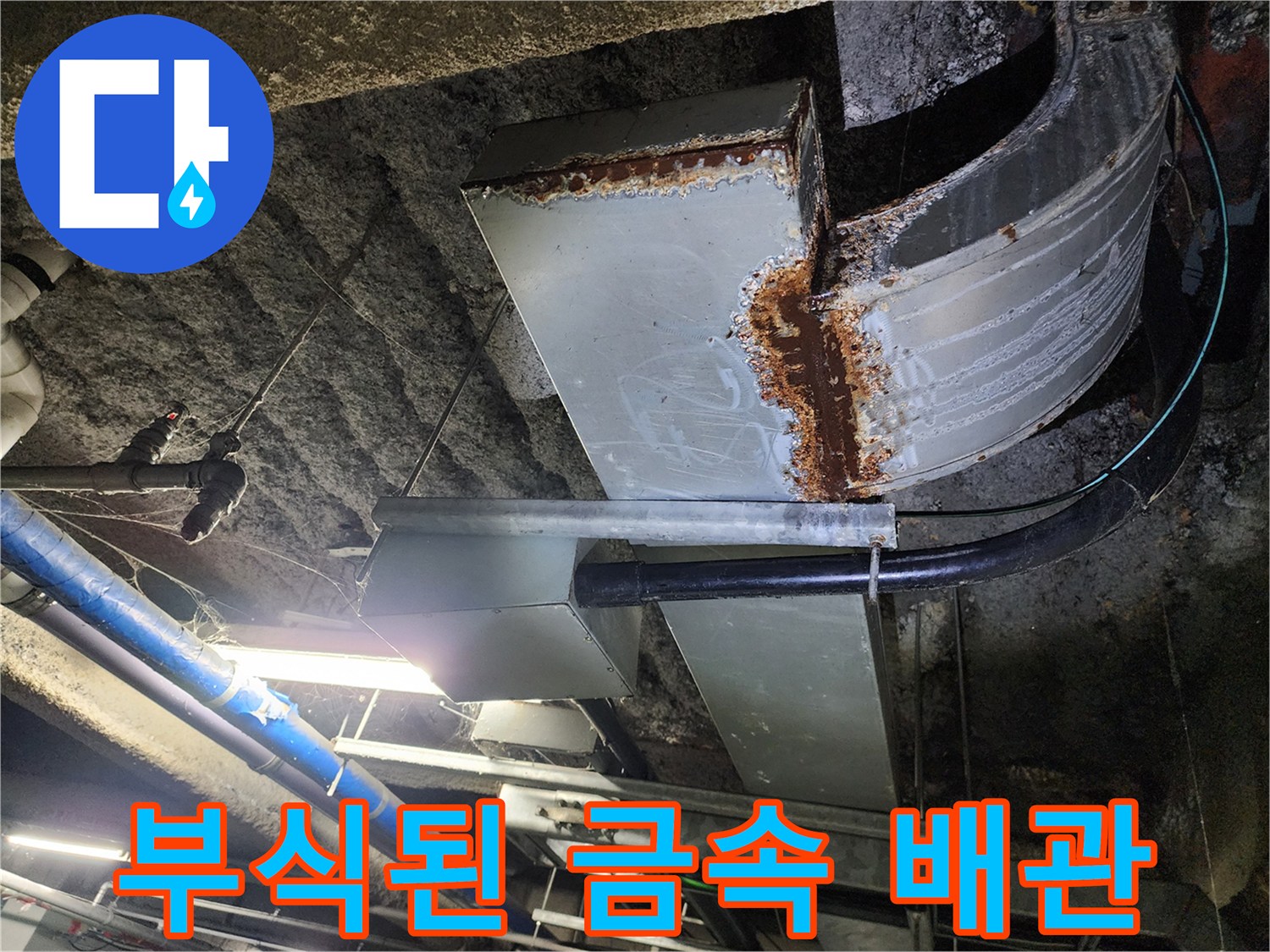 지하 주차장 천장에 설치된 부식되고 녹슨 금속 배관 모습