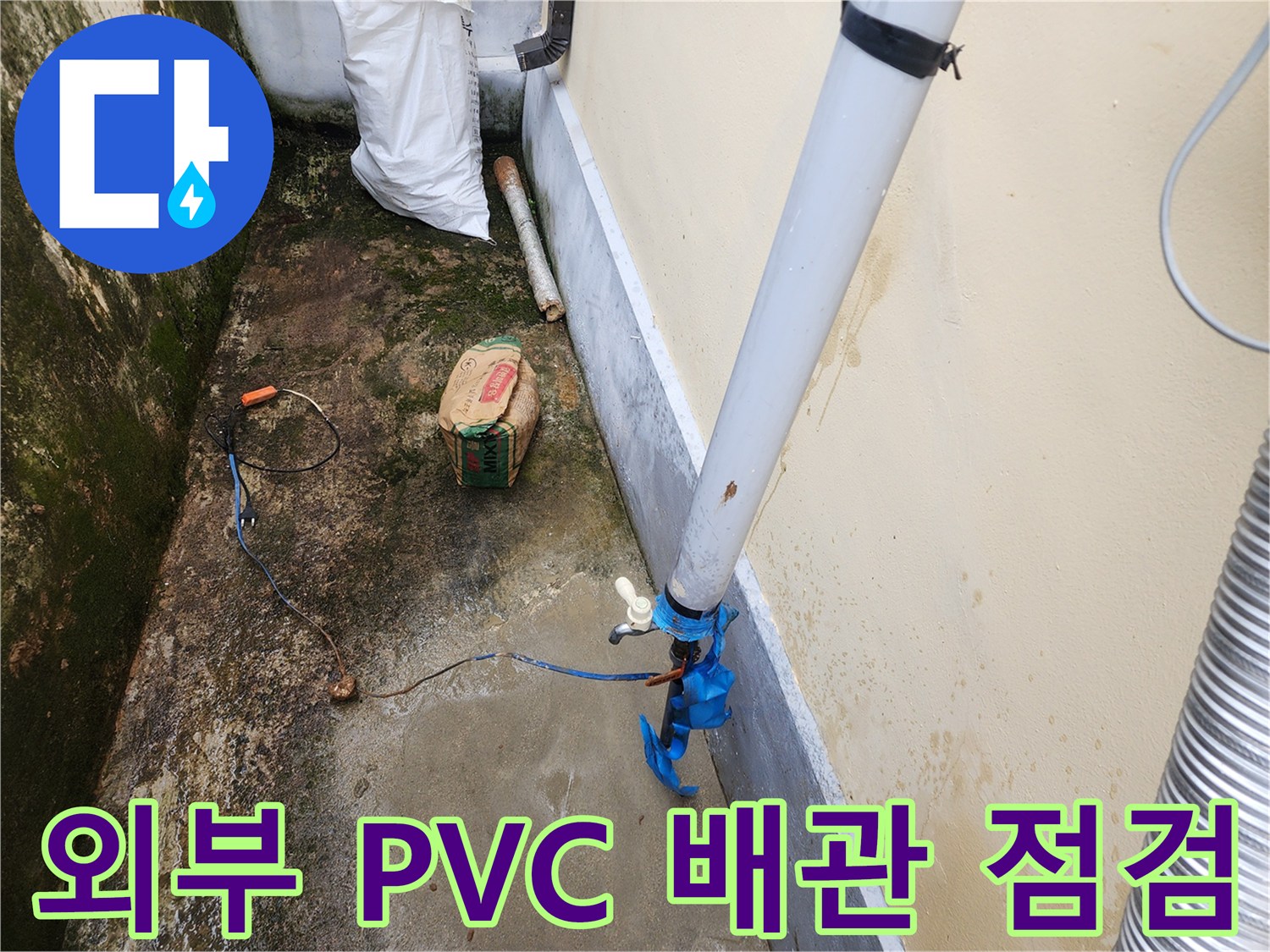 흰색 배관과 파란색 연결 부위가 보이는 건물 외부 작업 현장입니다.