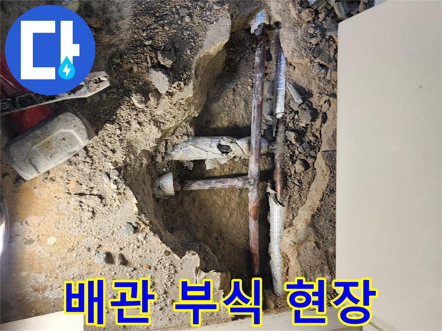 누수 지점 확인-부식된 금속 배관과 흙이 드러난 모습